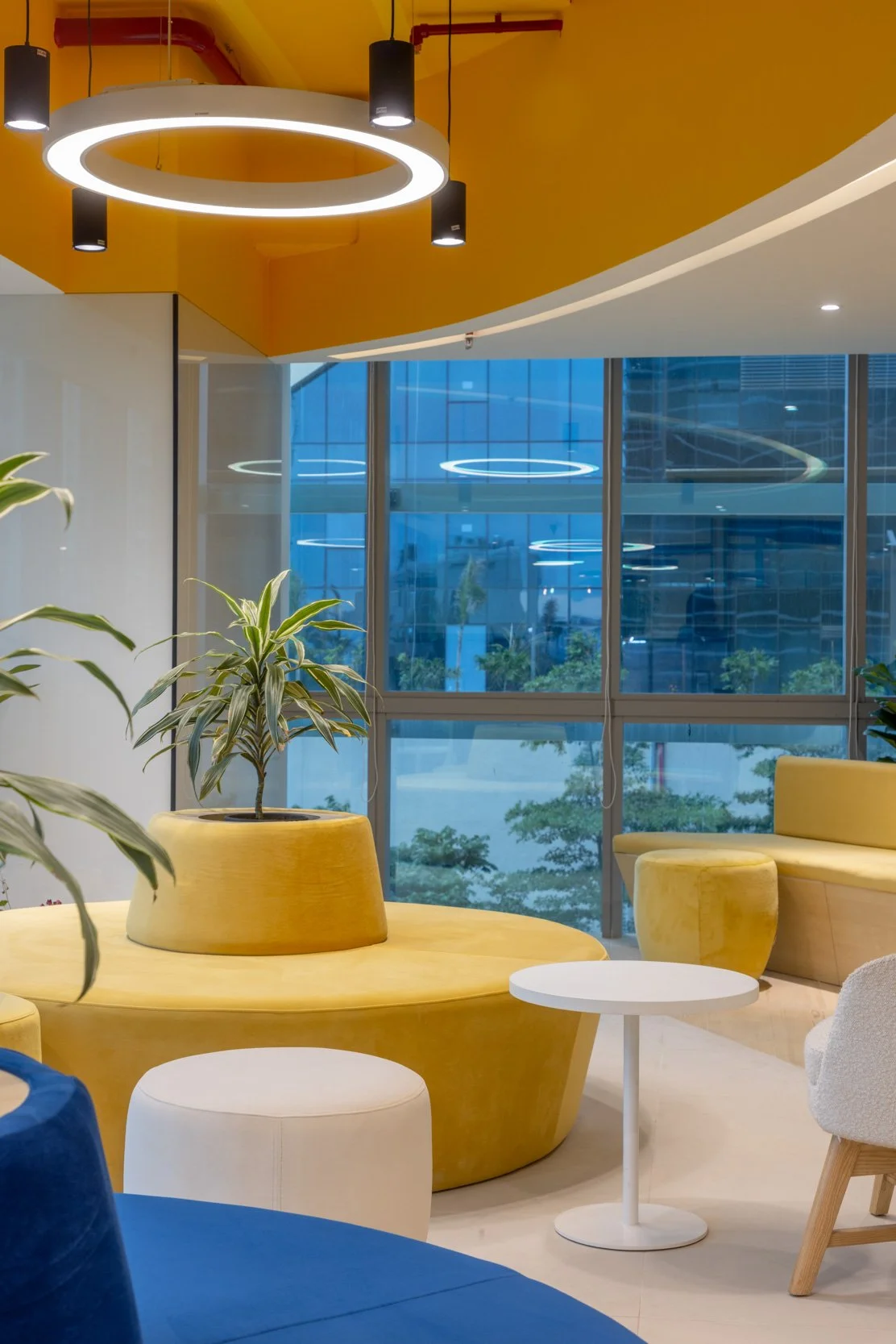 Commercial interior photography showcasing a colorful corporate breakout area, highlighting custom curved lounge seating, architectural lighting, and modern office design