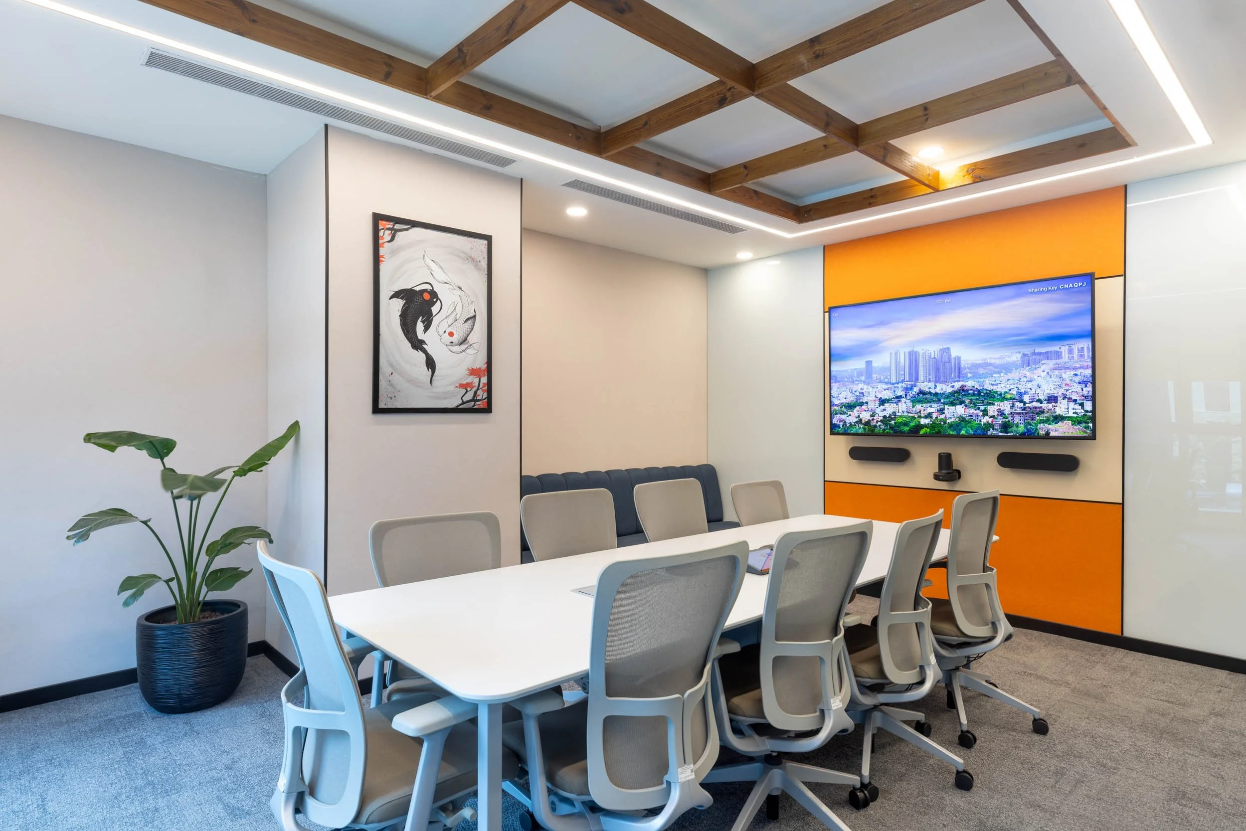 ommercial interior photography showcasing a modern corporate boardroomBased on the newly selected image in the gallery (the modern meeting room featuring a long conference table, grey ergonomic chairs, a bold orange accent wall, and a decorative wood