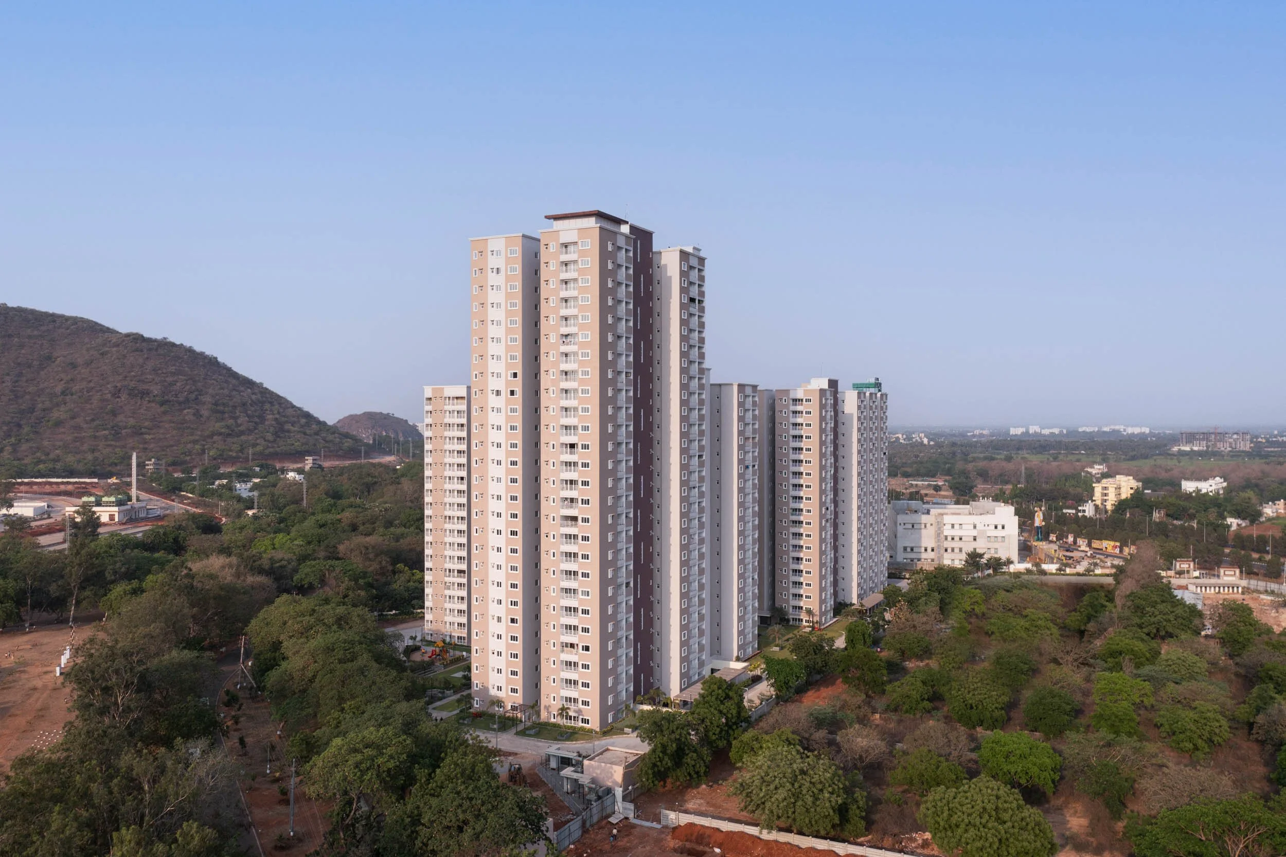 Aerial real estate photography showcasing modern residential towers integrated with natural landscapes and scenic mountain views