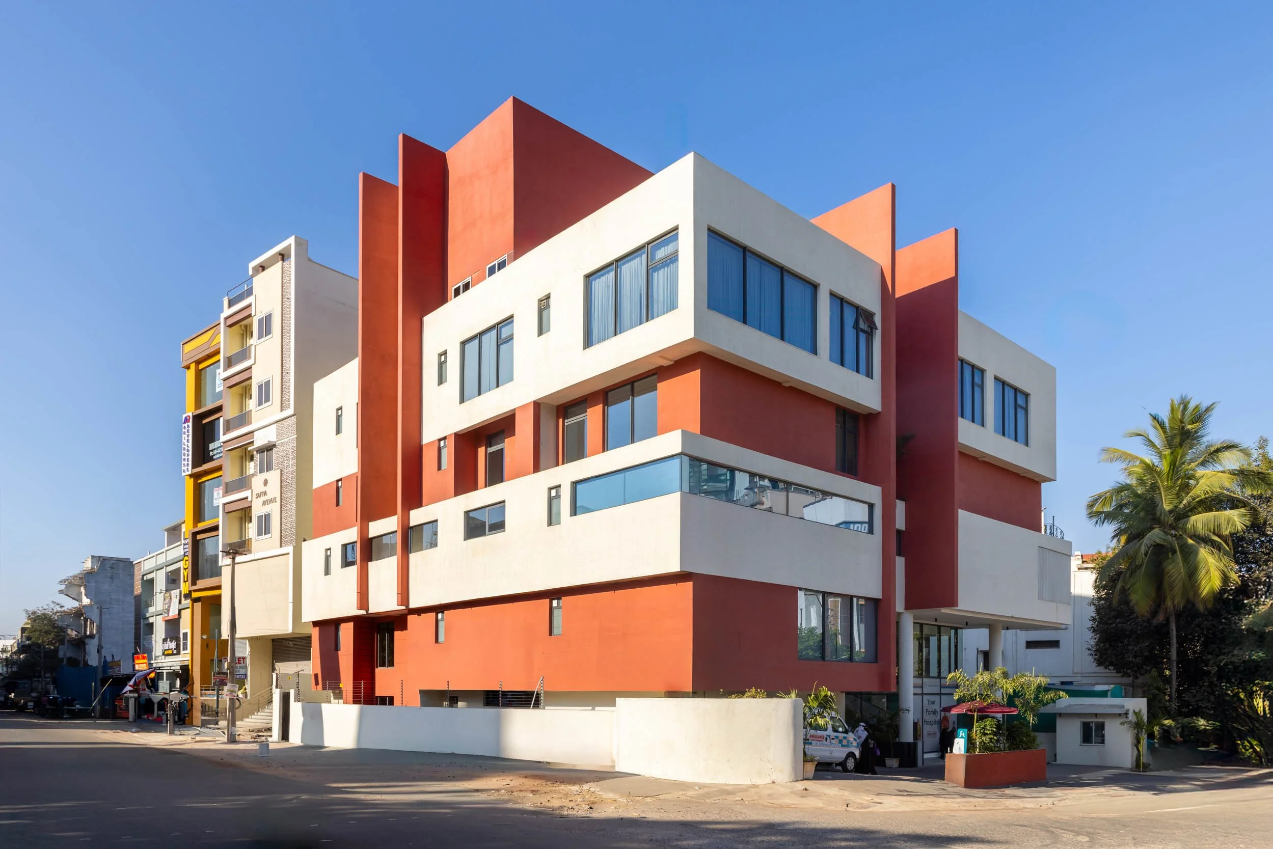 Exterior commercial architecture photography showcasing a modern geometric building design with vibrant orange and white facade details
