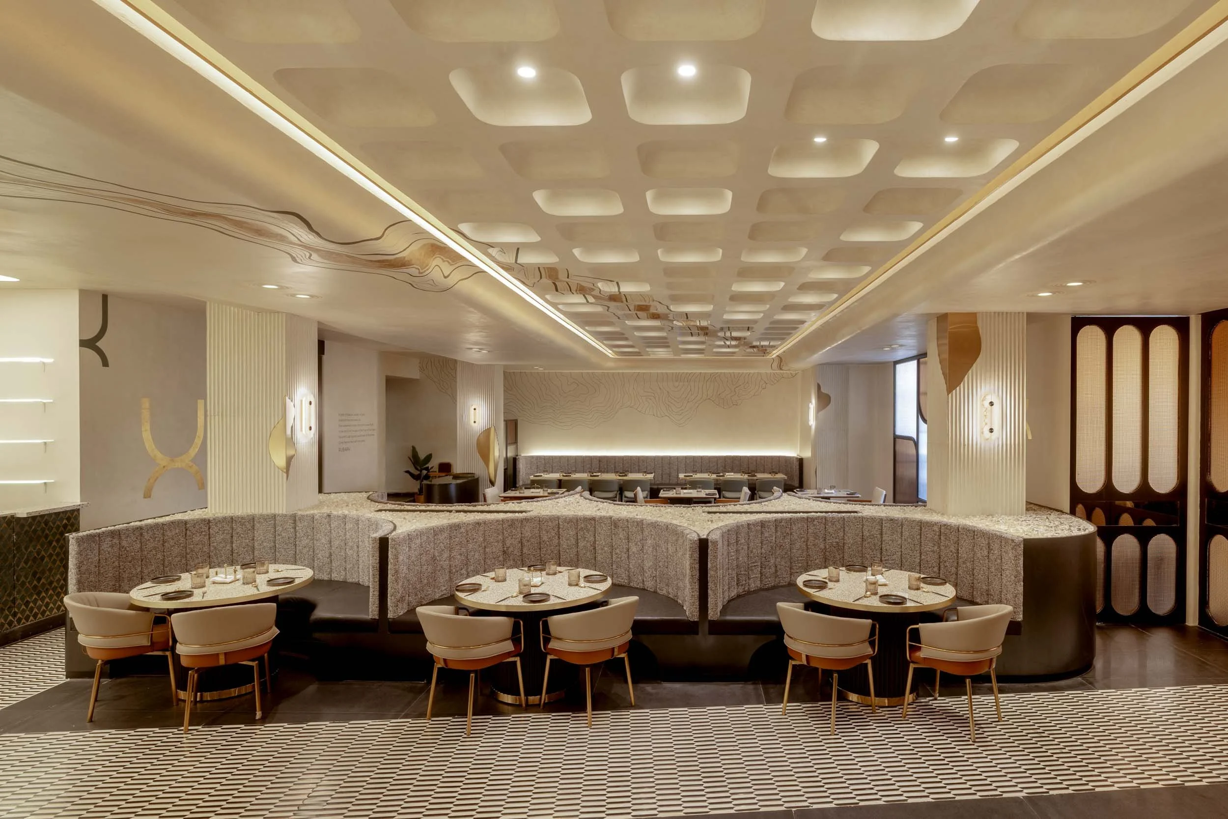 Commercial interior photography showcasing a luxury hospitality dining space, highlighting custom ceiling architecture, modern booth seating, and elegant restaurant interior design