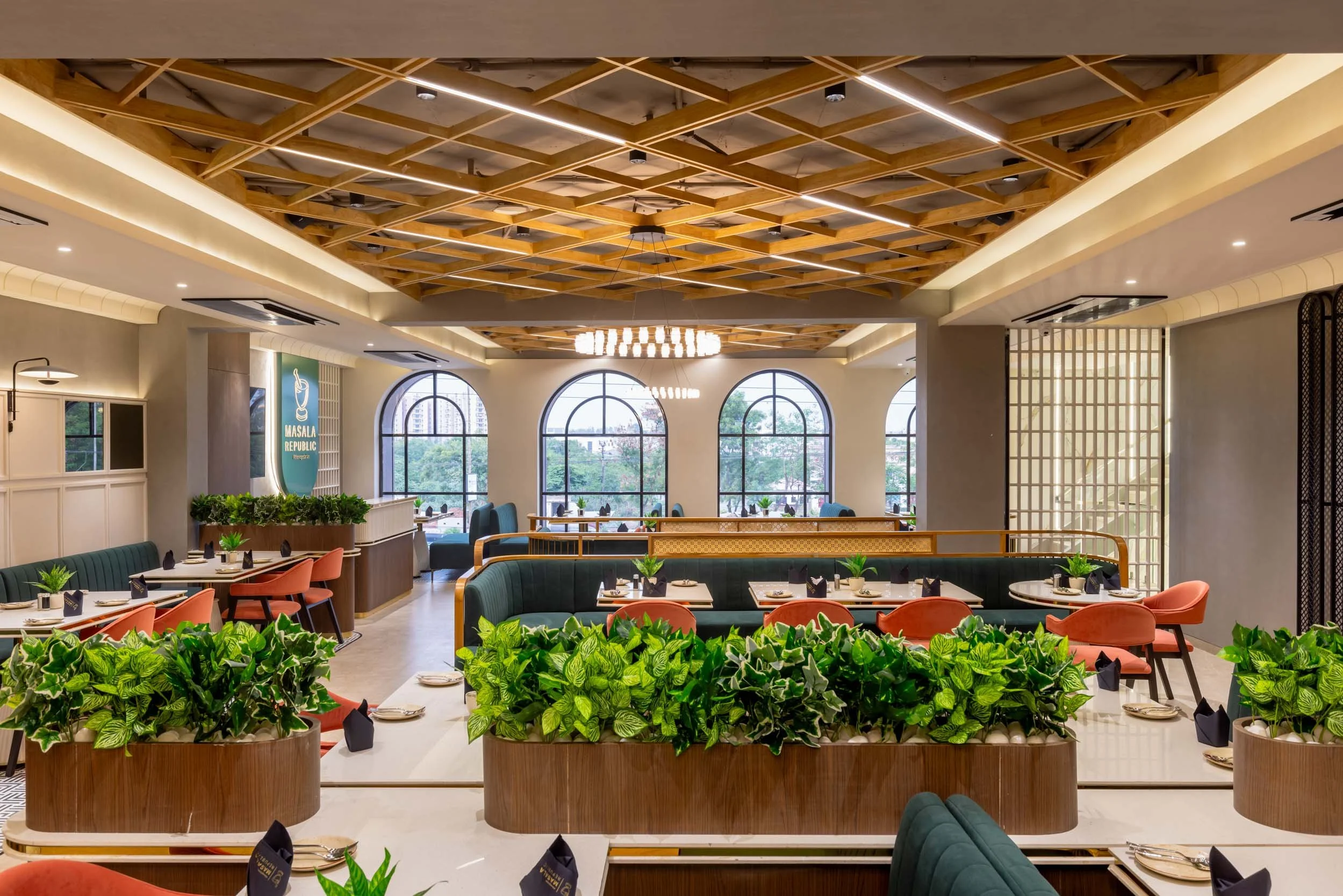 Commercial interior photography showcasing a vibrant hospitality environment, highlighting custom wood ceiling architecture, arched windows, and biophilic restaurant interior design