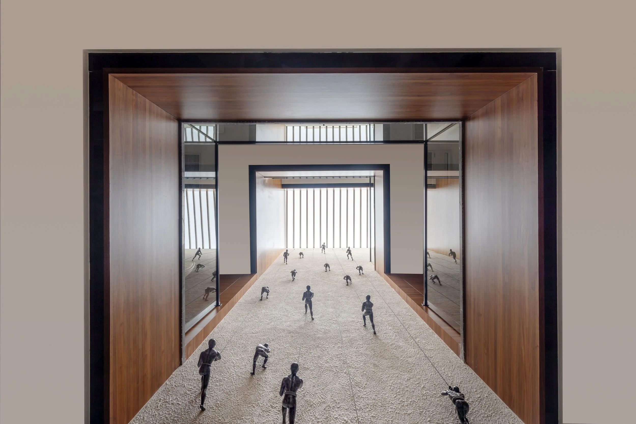 Professional interior architectural photography showcasing a grand, symmetrical corridor with dark wood framing, polished floors, and blurred figures conveying scale and movement.