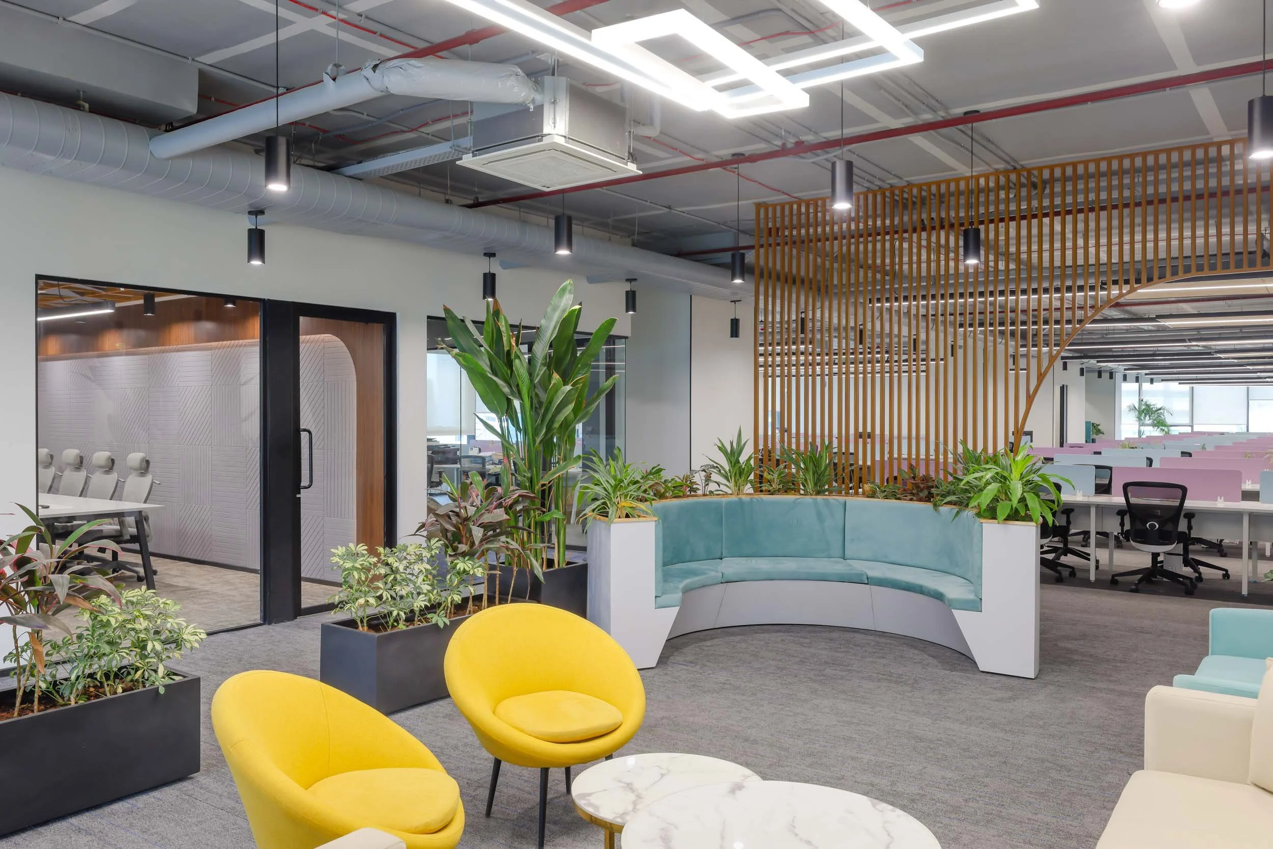 Commercial interior photography showcasing a creative corporate breakout space, highlighting colorful lounge seating, open-plan office design, and vibrant yellow accent furniture