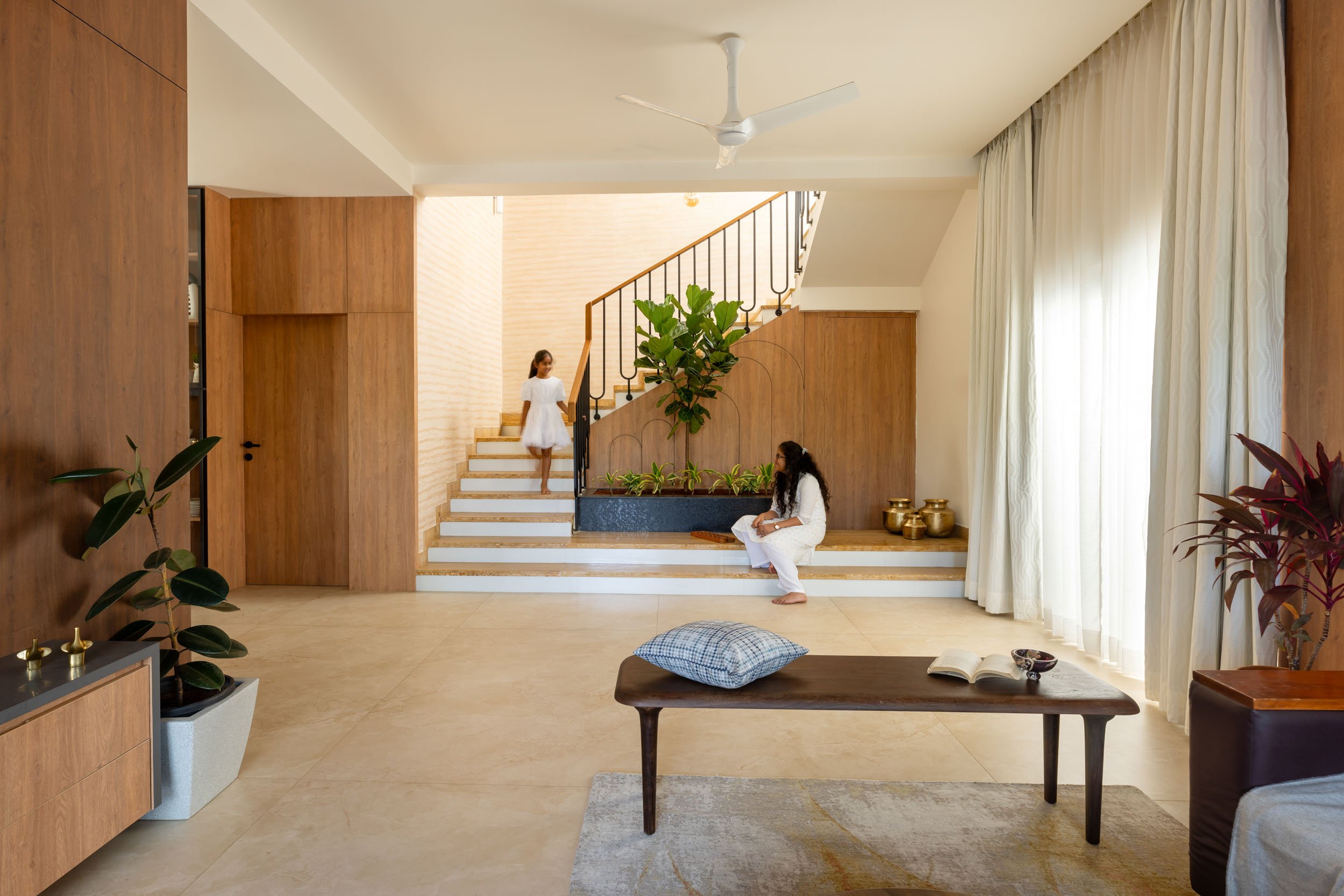 Professional interior photography of a bright, modern open-plan residential space featuring a split-level design and abundant natural light.