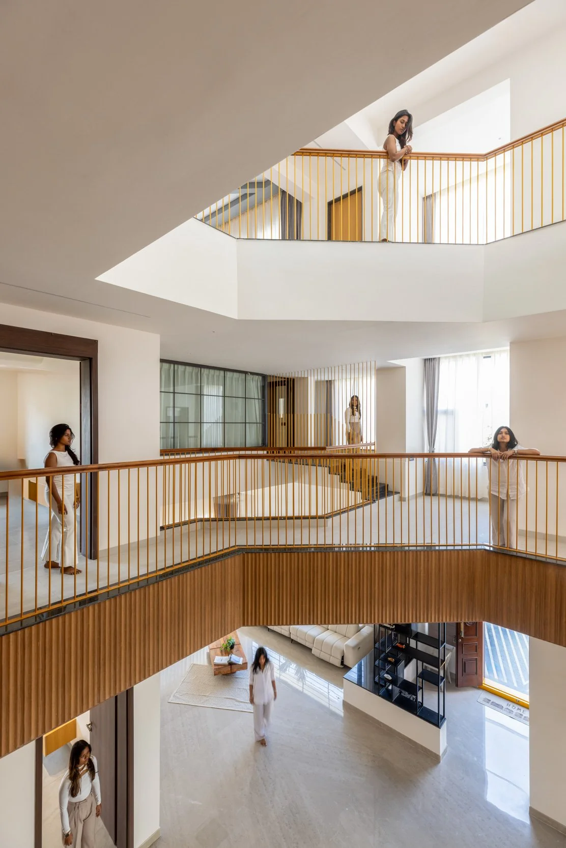 Professional interior architectural photography showcasing a stunning multi-level residential atrium with curved wooden balconies and walkways.