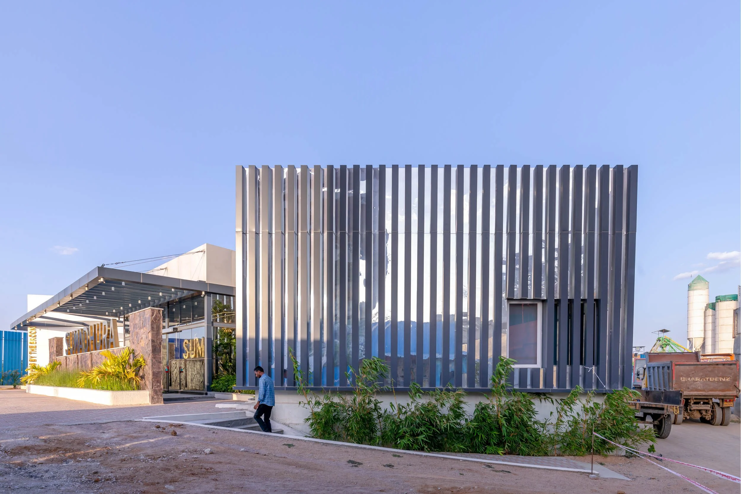 Exterior commercial architecture photography showcasing a modern office building design with striking vertical architectural louvers and integrated landscaping