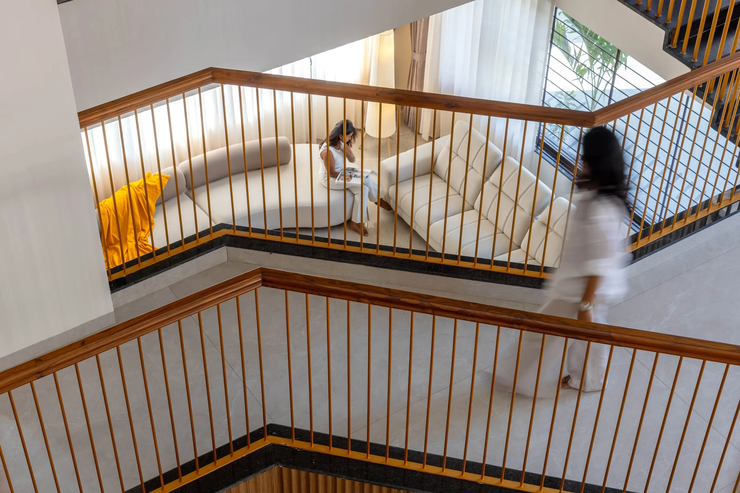 Professional interior architectural photography of a modern residential home, capturing a wooden staircase with glass railings and vertical slatted wall details
