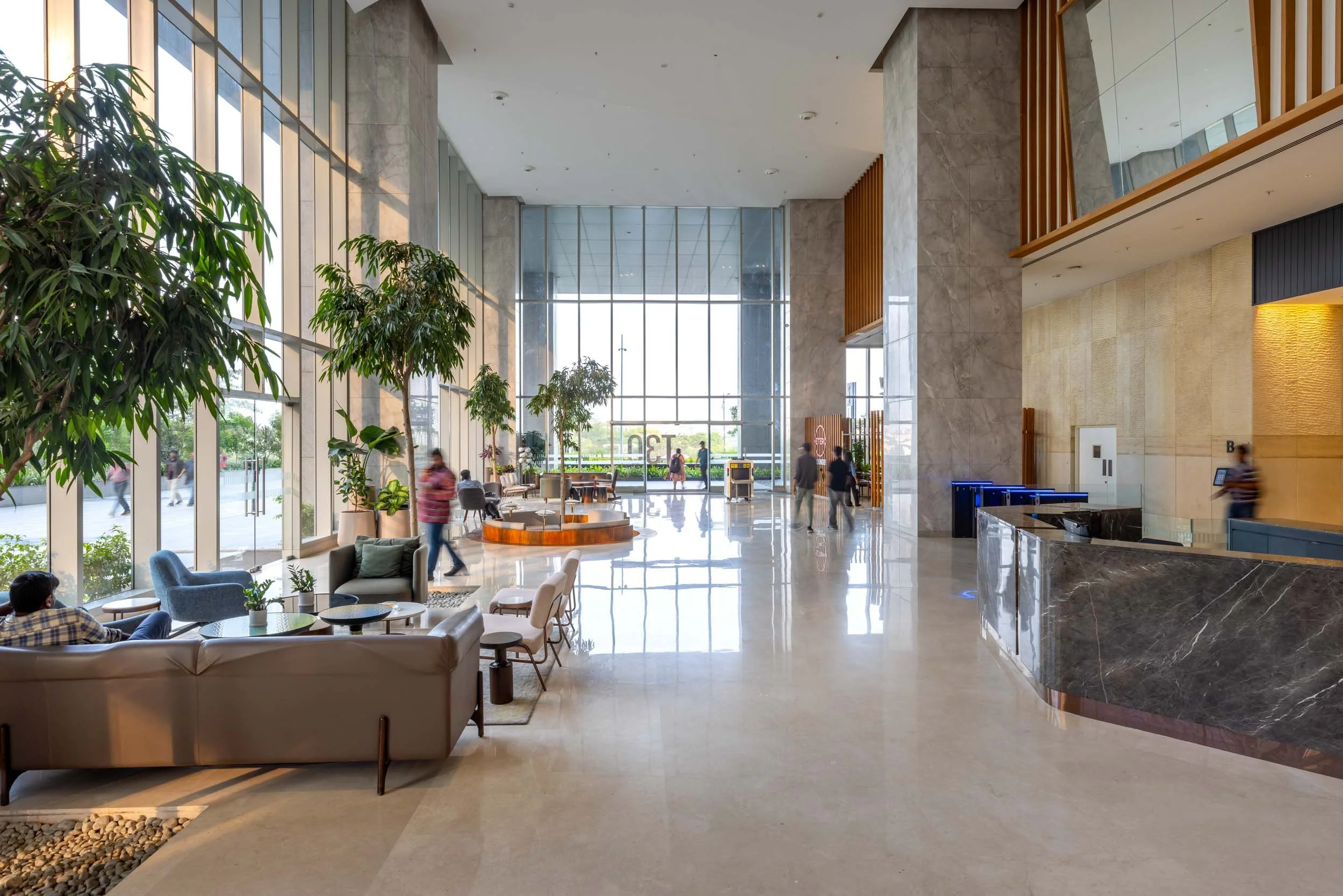 Professional interior architecture photography of a spacious modern commercial lobby, highlighting expansive glass walls, abundant natural light, and an inviting, grand scale