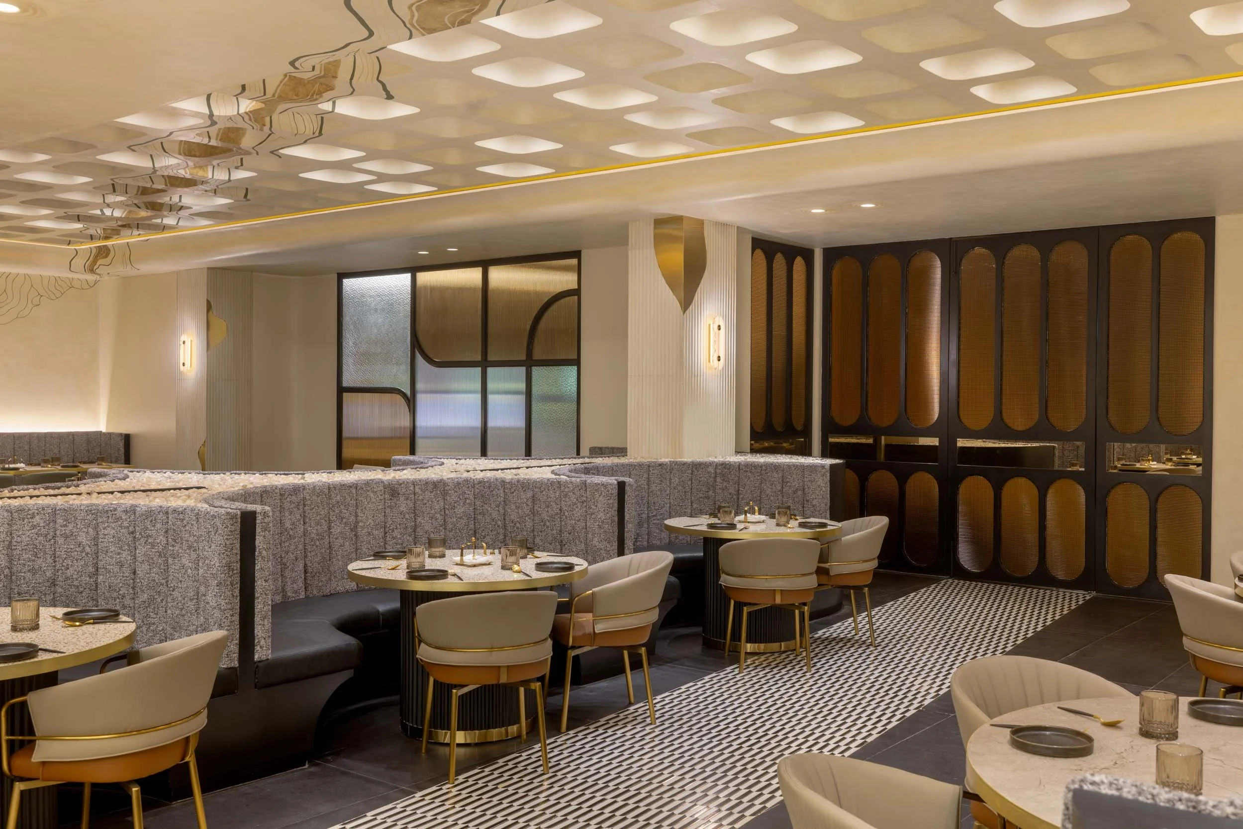 Commercial interior photography showcasing a luxury restaurant dining space, highlighting custom booth seating arrangements, intricate ceiling architecture, and sophisticated hospitality interior design.