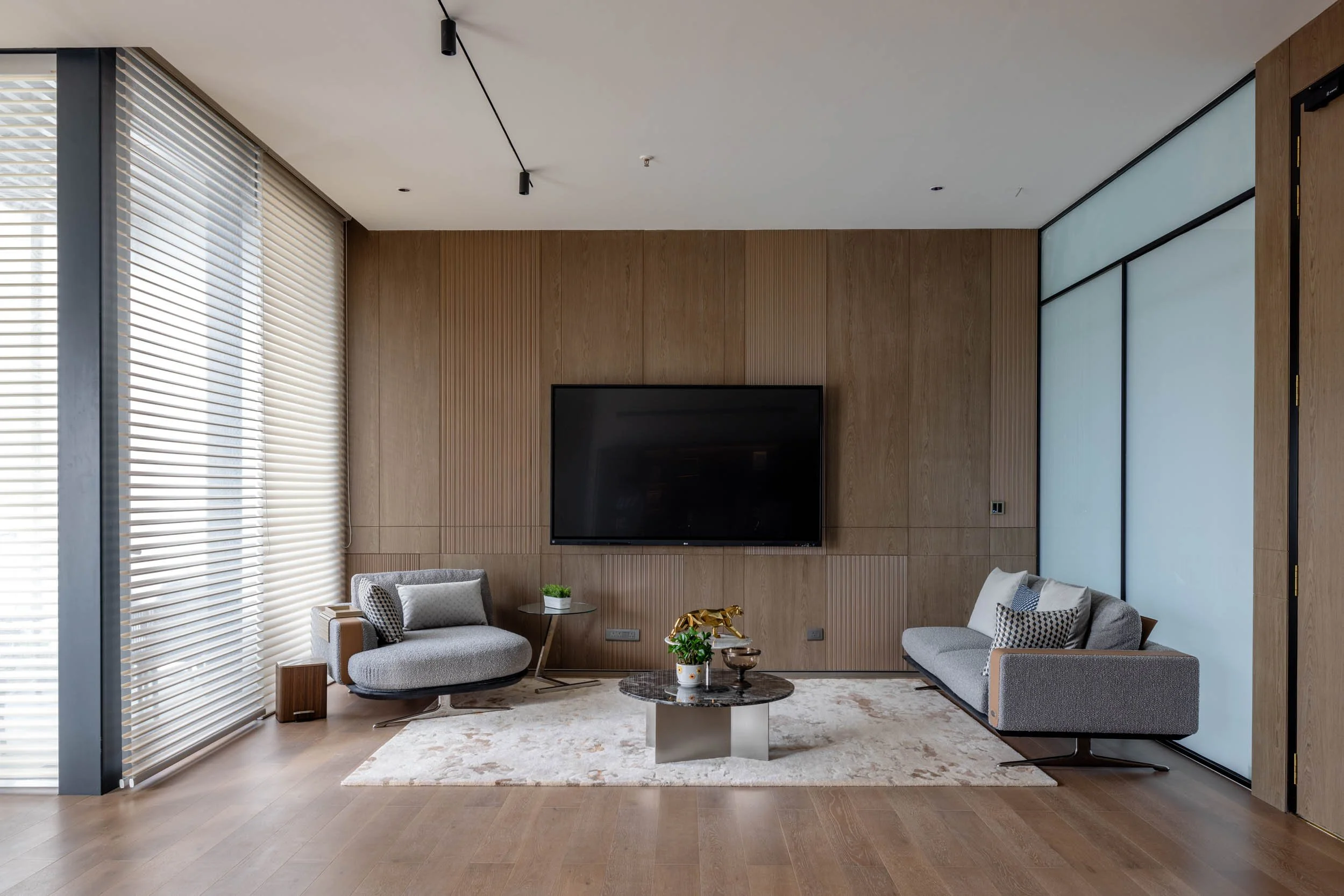 Commercial interior photography showcasing a luxury executive lounge, highlighting custom wood wall paneling, elegant modern office furniture, and refined workspace design