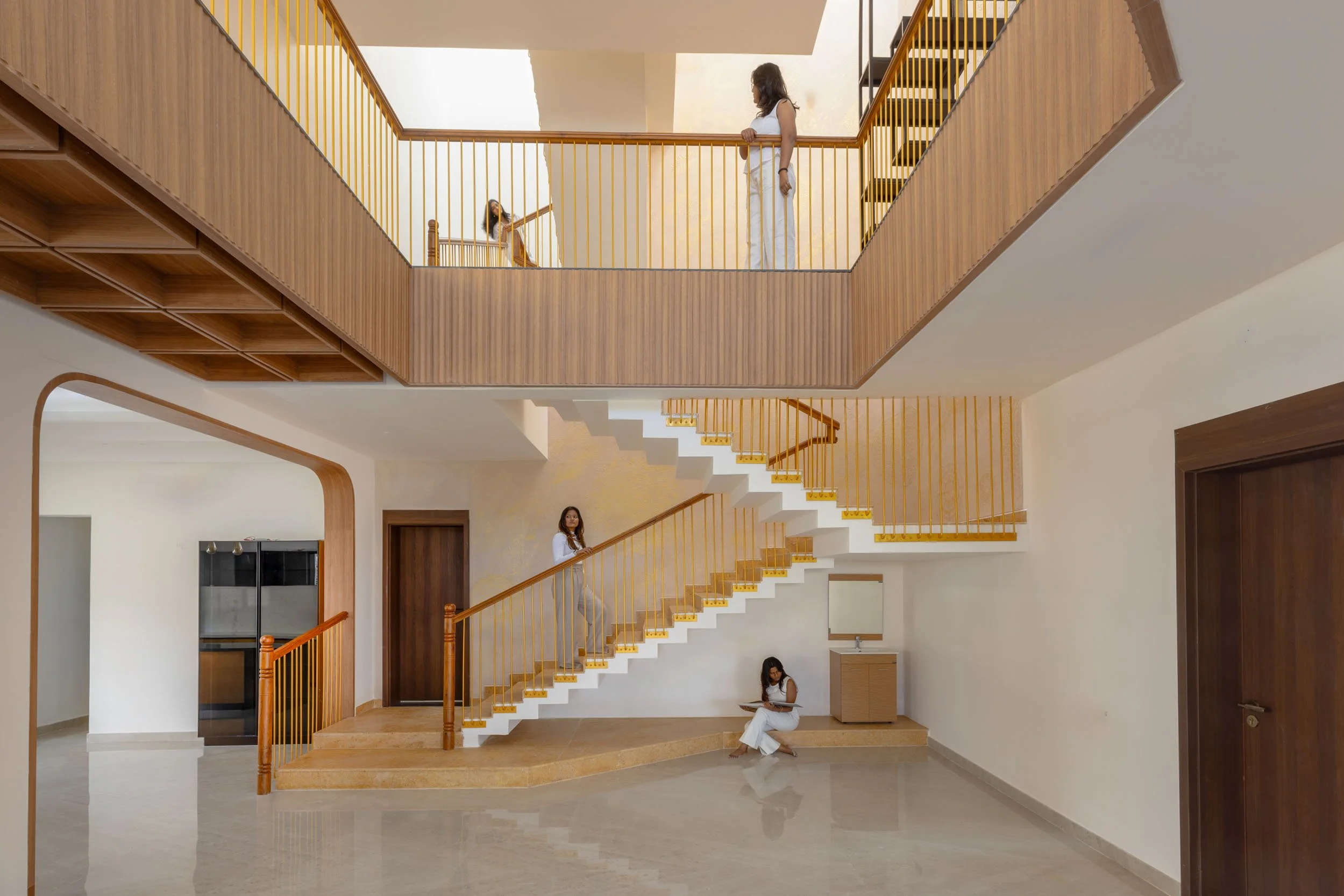 Professional interior architectural photography of a spacious, multi-level modern residential home featuring a striking wooden staircase and open walkways