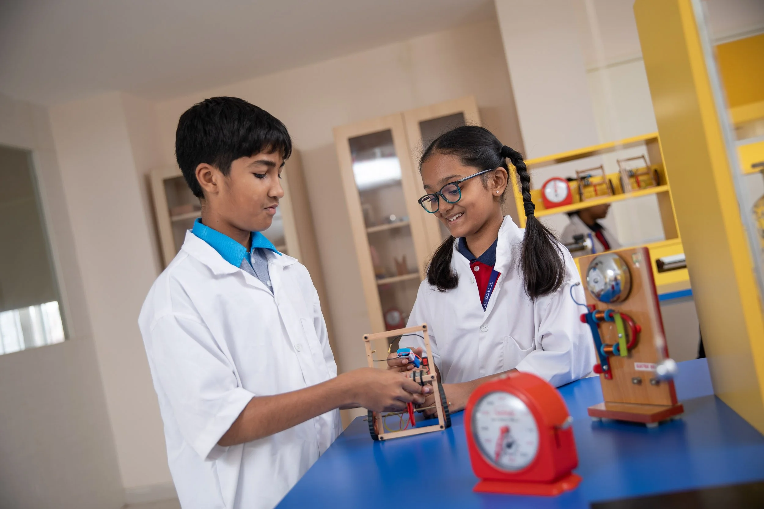 Interior school photography of students in lab coats conducting an experiment in a modern science laboratory