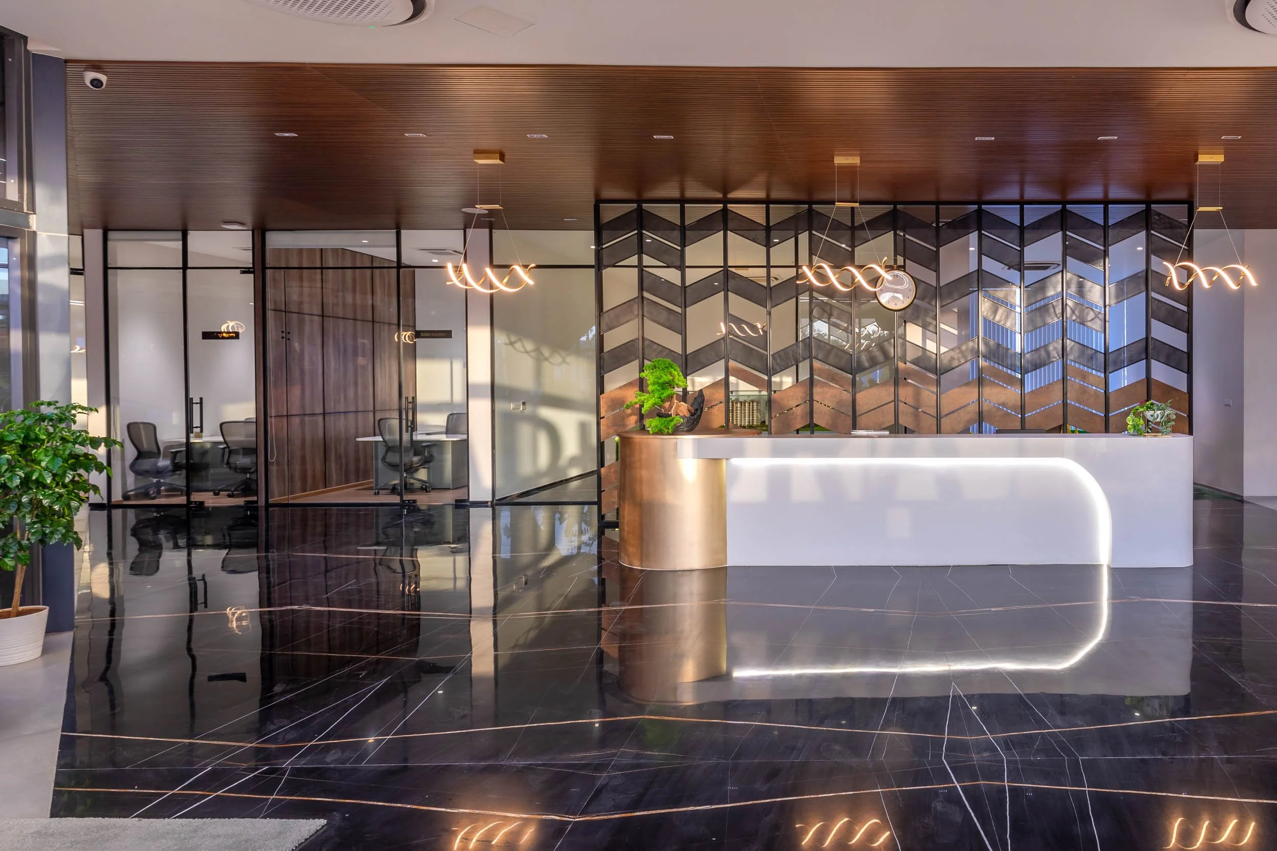 Interior commercial architecture photography of a modern luxury office lobby, highlighting a contemporary reception desk, high-gloss floors, and warm ambient lighting.