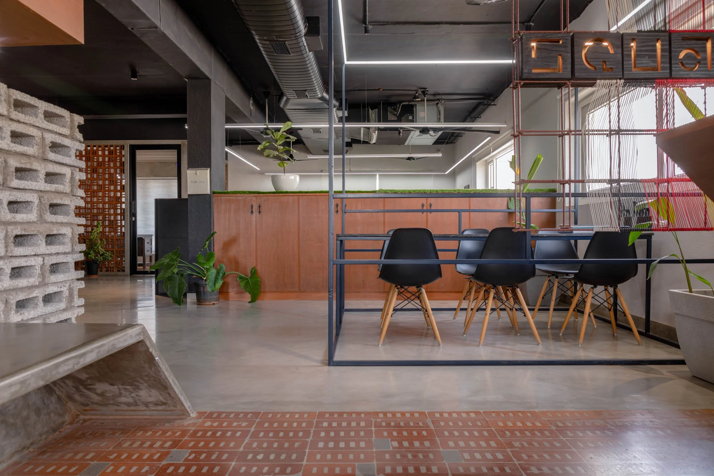 Commercial interior photography showcasing an industrial-style corporate workspace, highlighting a raised meeting area, open ceilings, and modern office design