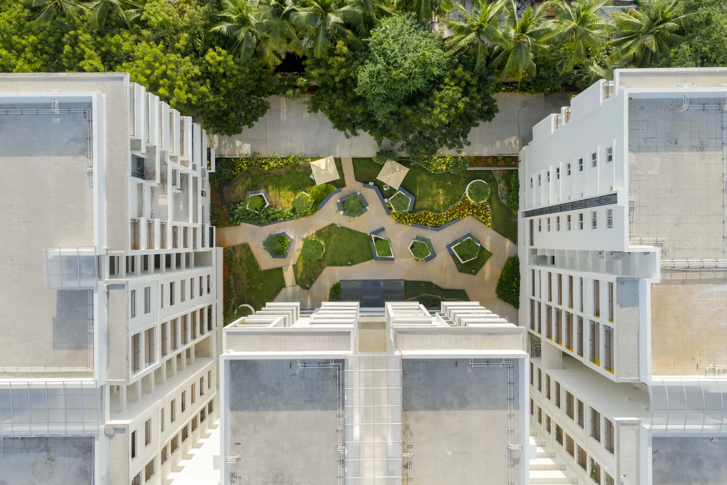 Aerial residential real estate photography capturing the geometric layout, modern architecture, and central green spaces of a high-density apartment complex