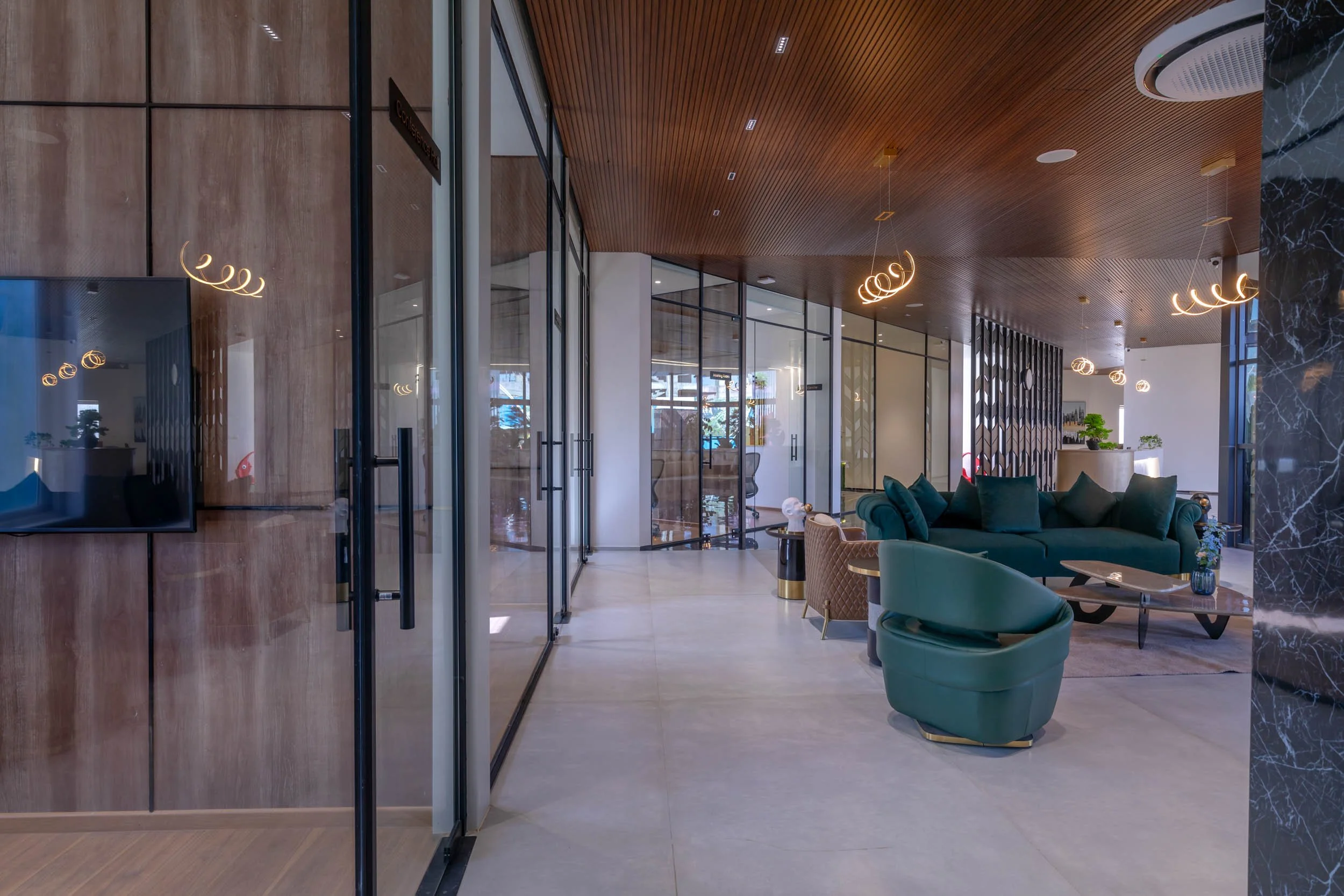 Interior commercial architecture photography showcasing a modern office lobby with expansive glass windows, warm wood ceiling details, and a welcoming seating area