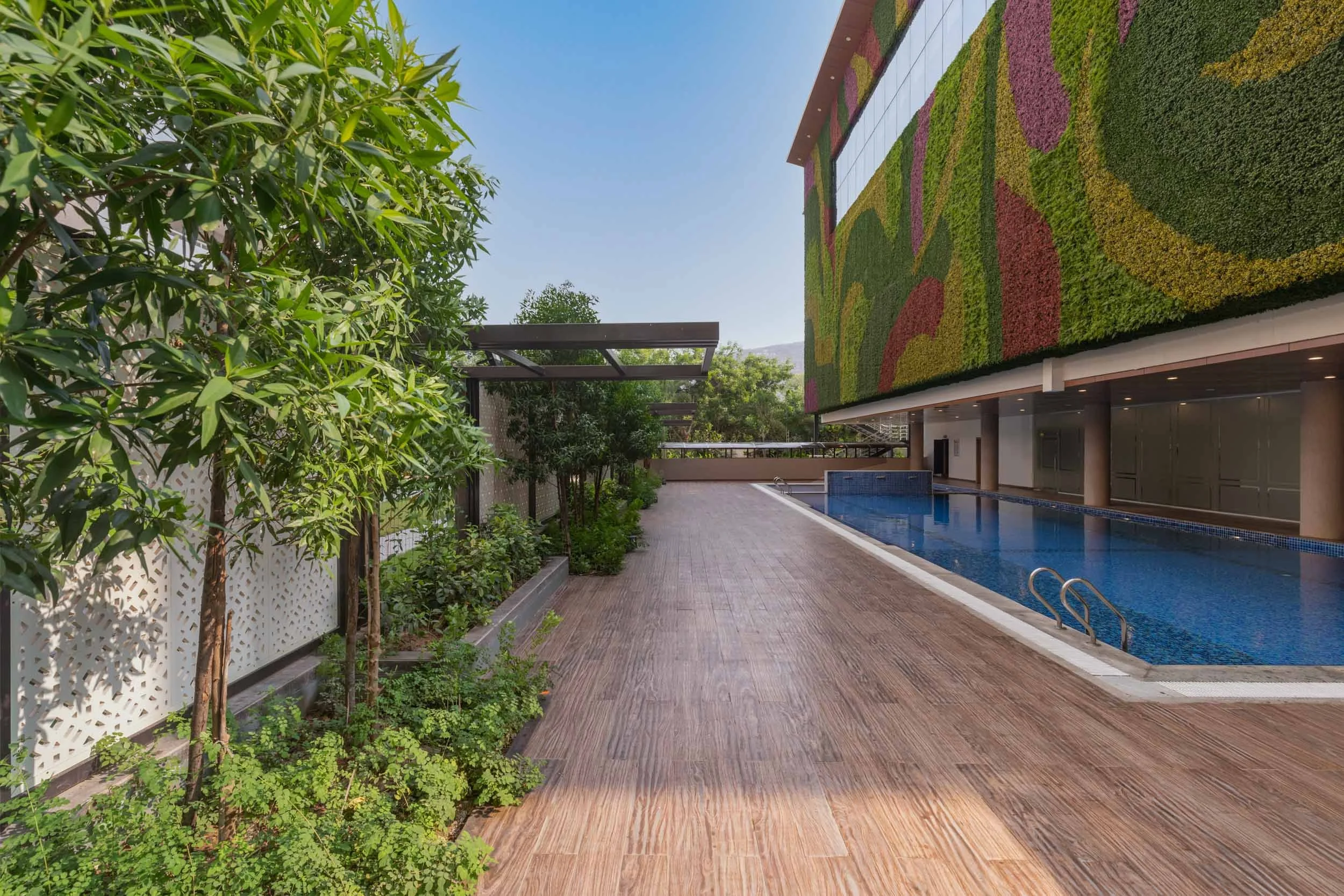 Real estate exterior photography highlighting a lush living wall, a decorative water feature, and a beautifully landscaped pedestrian walkway.