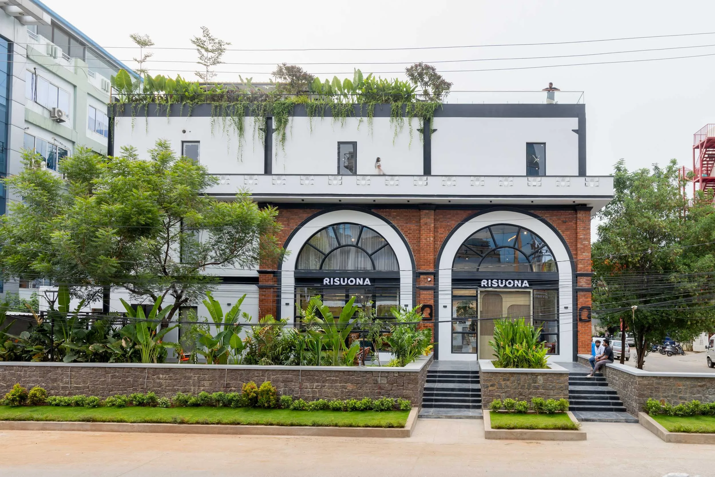 Commercial architecture photography showcasing a modern storefront design with arched entrances and a seamlessly integrated landscaped approach