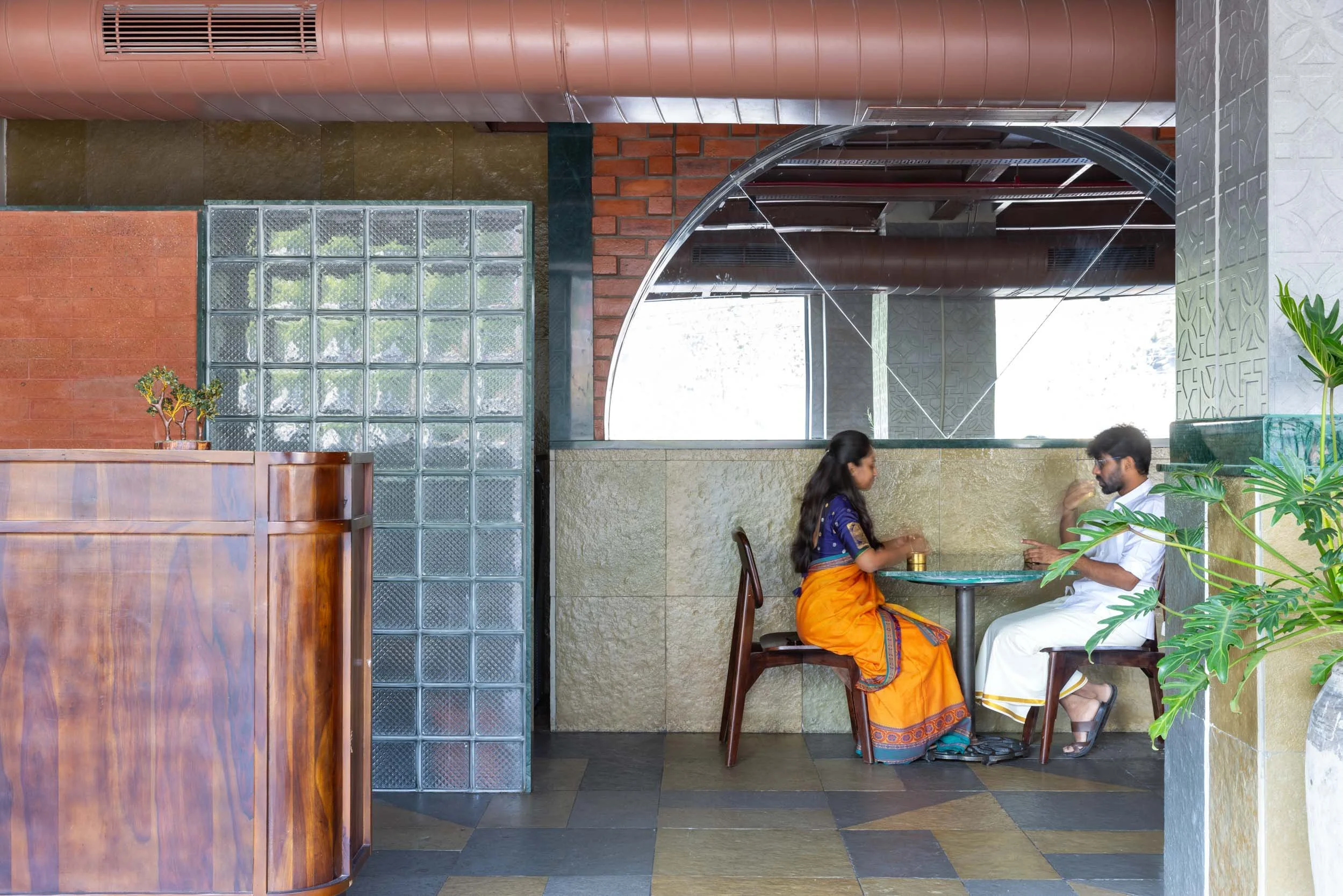 Commercial interior and lifestyle photography showcasing a modern cafe space, highlighting glass block walls, vibrant architectural colors, and inviting hospitality design