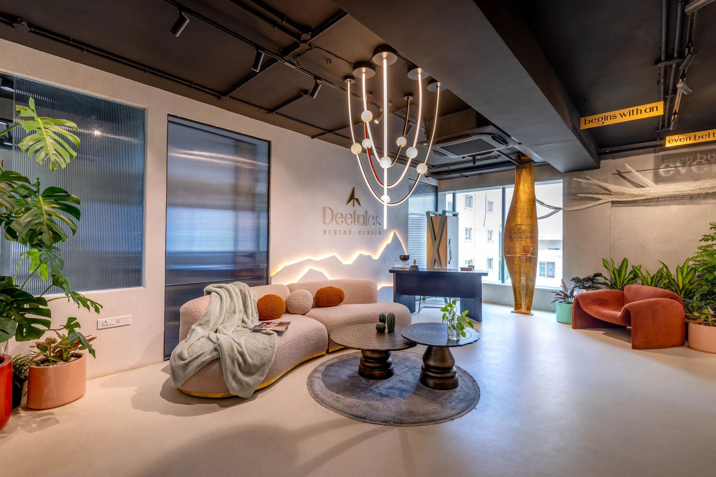 Commercial interior photography of a modern corporate breakout space, highlighting custom statement lighting, colorful lounge seating, and expansive open-plan architecture