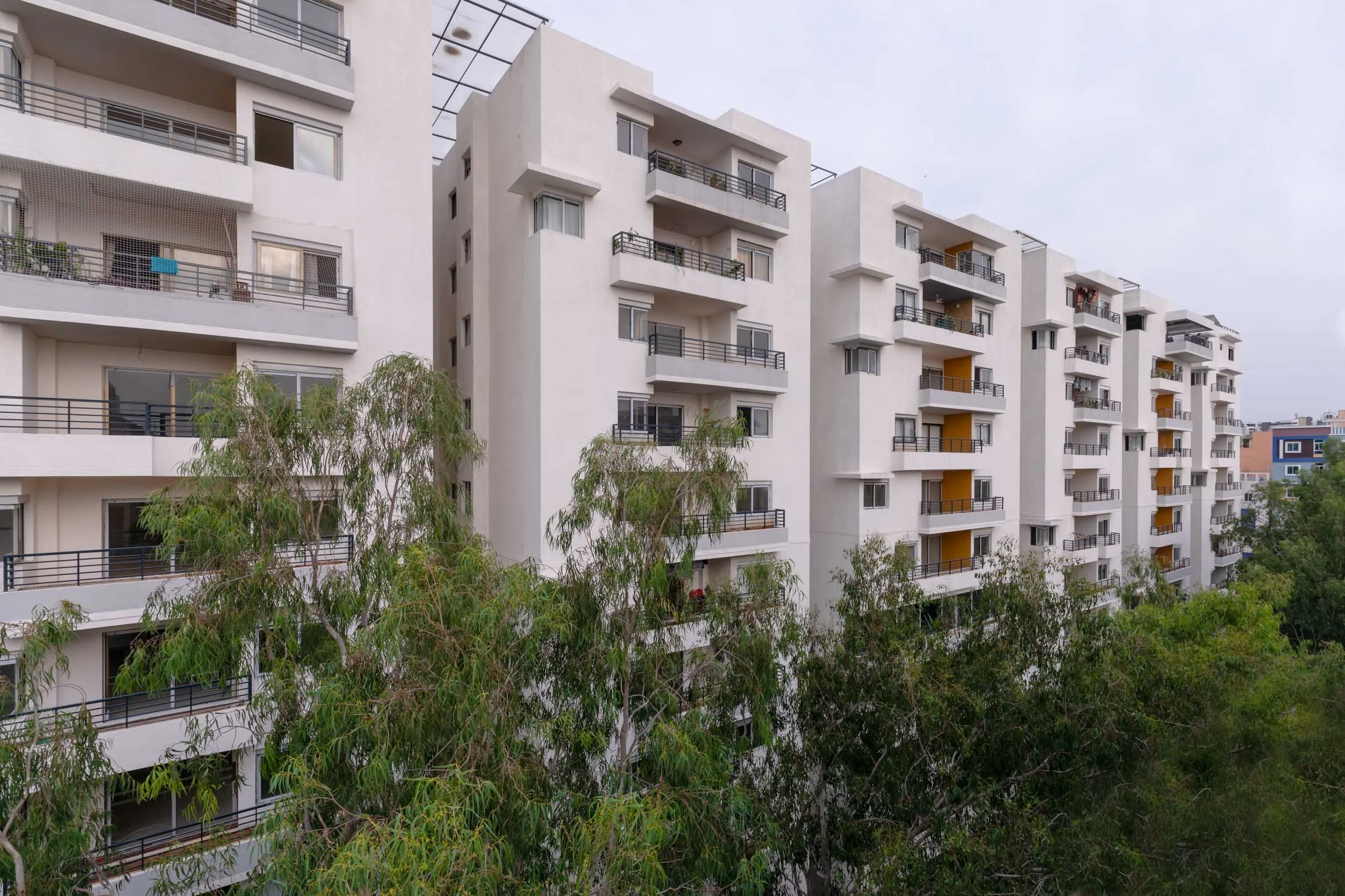 Residential real estate exterior photography capturing a peaceful apartment complex integrated with nature and abundant green spaces