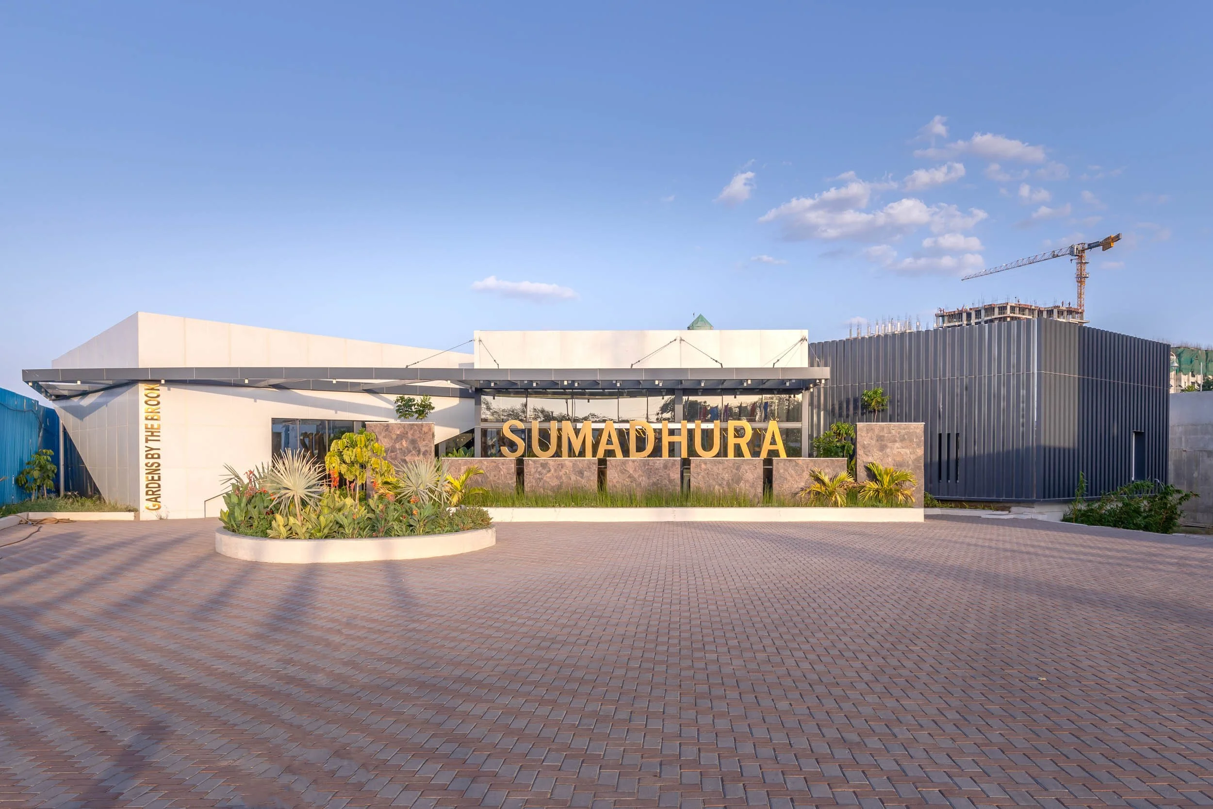Exterior commercial architecture photography showcasing a sprawling modern corporate campus, highlighting a wide entrance plaza, clean geometric lines, and clear blue skies