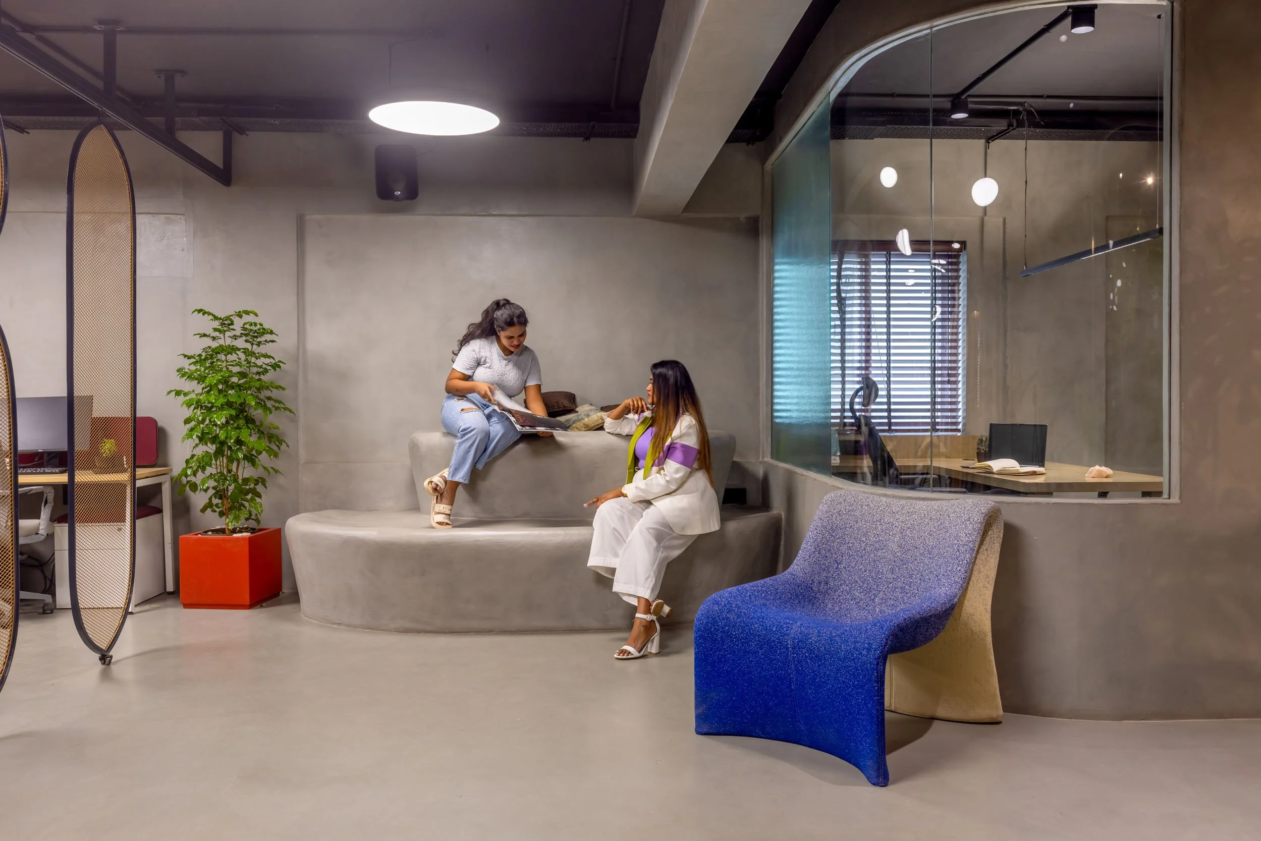 Commercial interior photography showcasing a modern corporate breakout area, highlighting industrial office design, collaborative seating arrangements, and vibrant lounge furniture