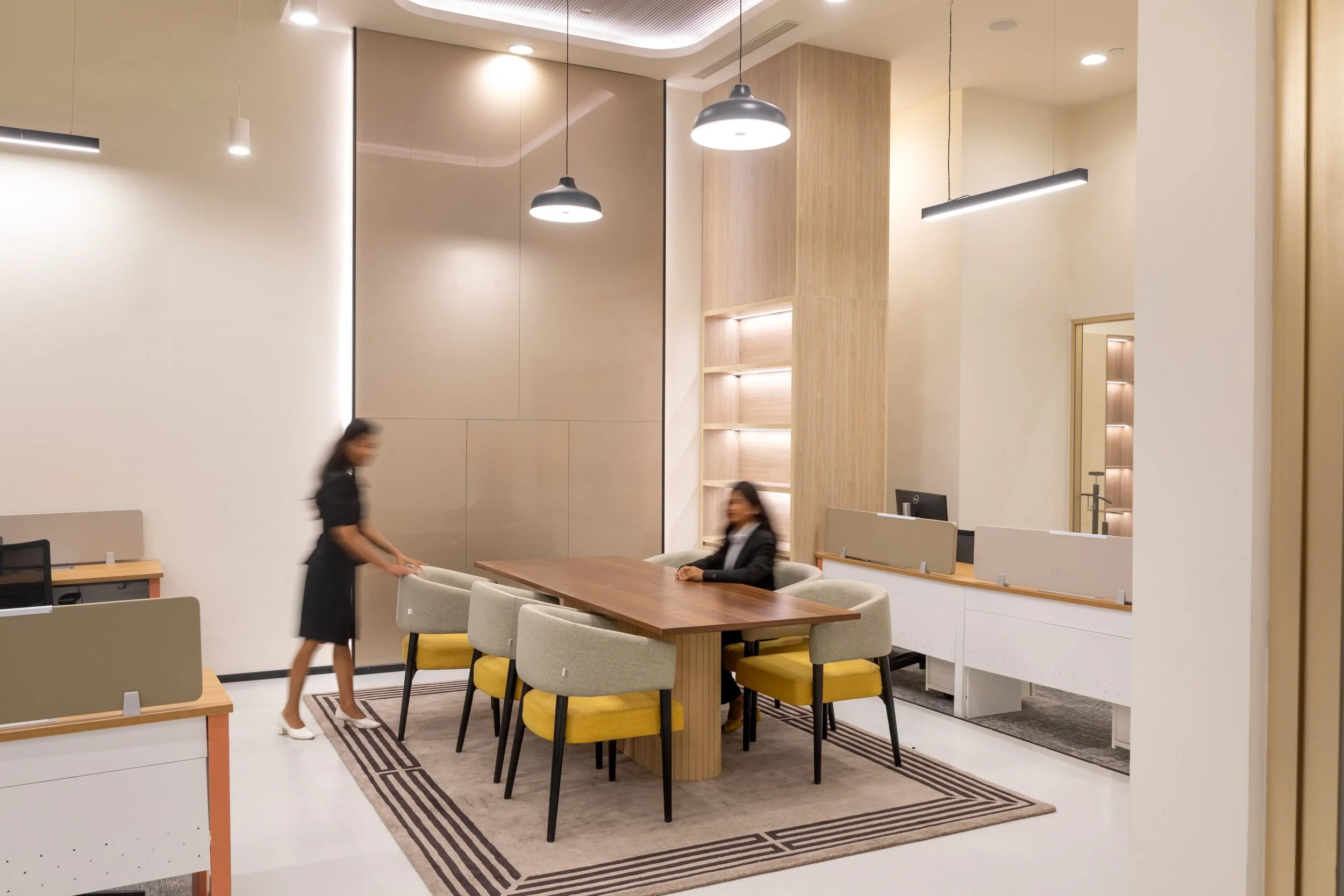 Commercial interior photography showcasing a modern corporate workspace and breakout area, highlighting warm lighting, contemporary furnishings, and a collaborative layout.