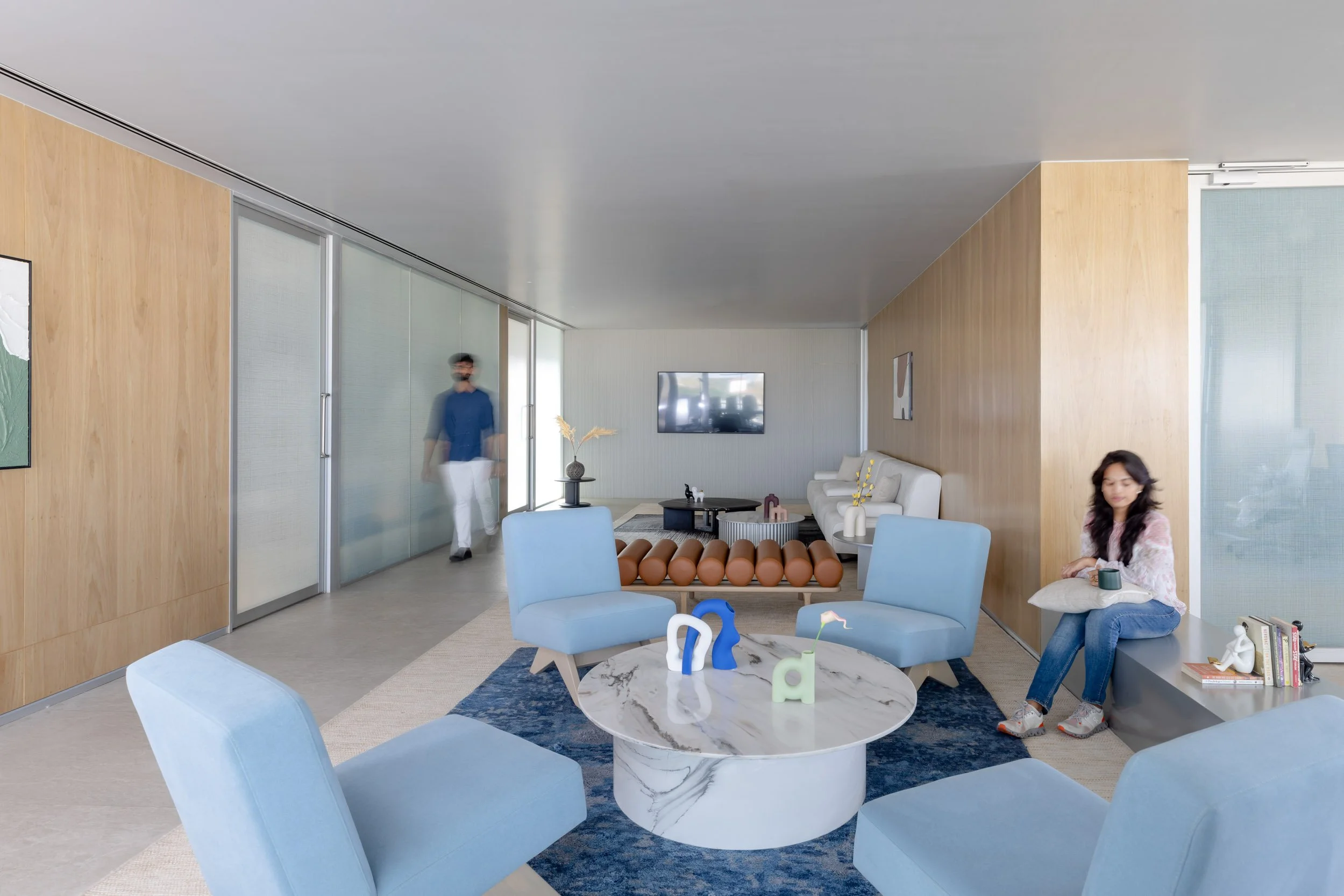 Commercial interior photography showcasing a spacious corporate lounge and breakout area, highlighting modern seating arrangements, natural lighting, and custom architectural wood details