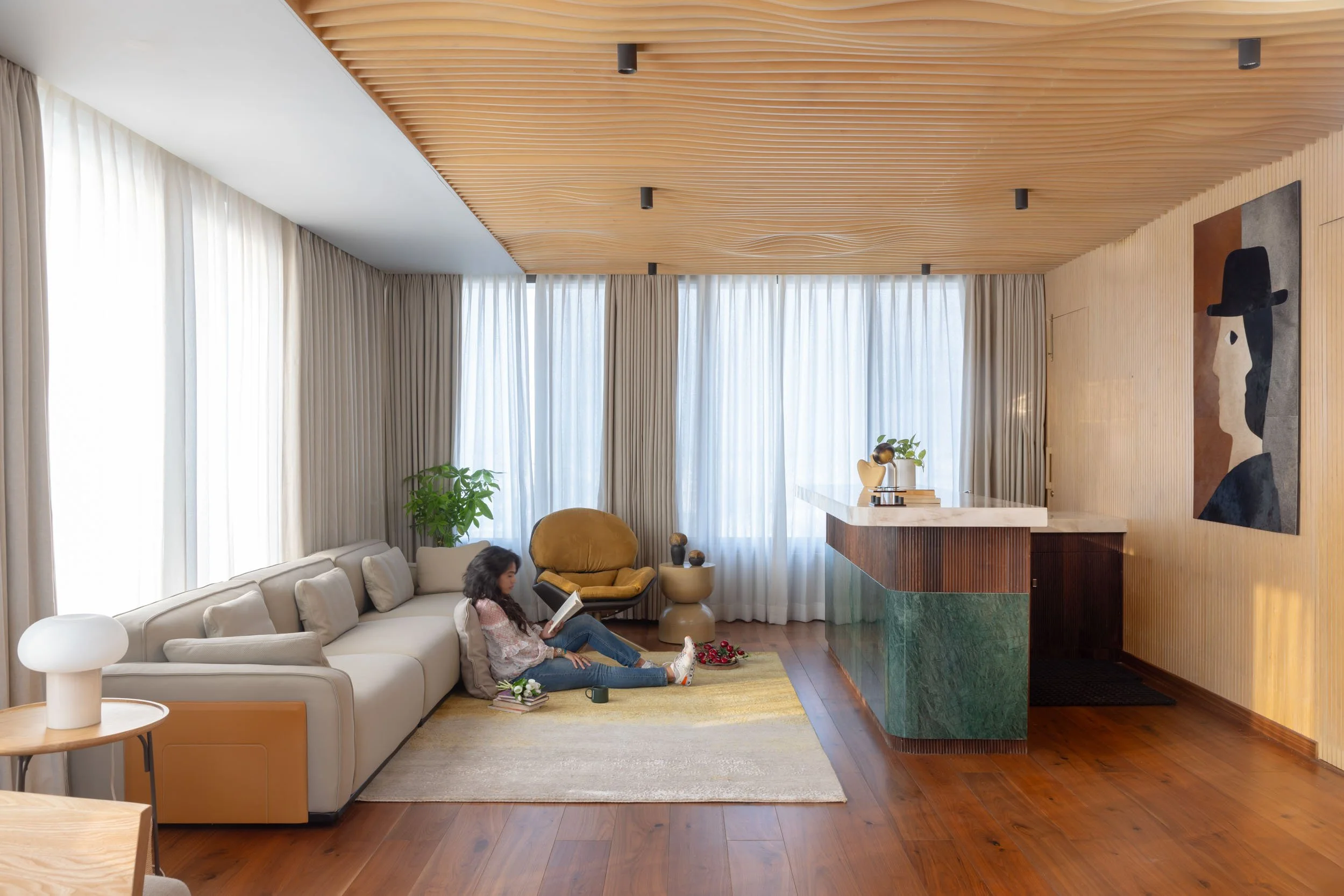 Commercial interior photography showcasing a luxury corporate breakout area and lounge space, highlighting custom architectural wood ceilings, modern furnishings, and bright natural lighting
