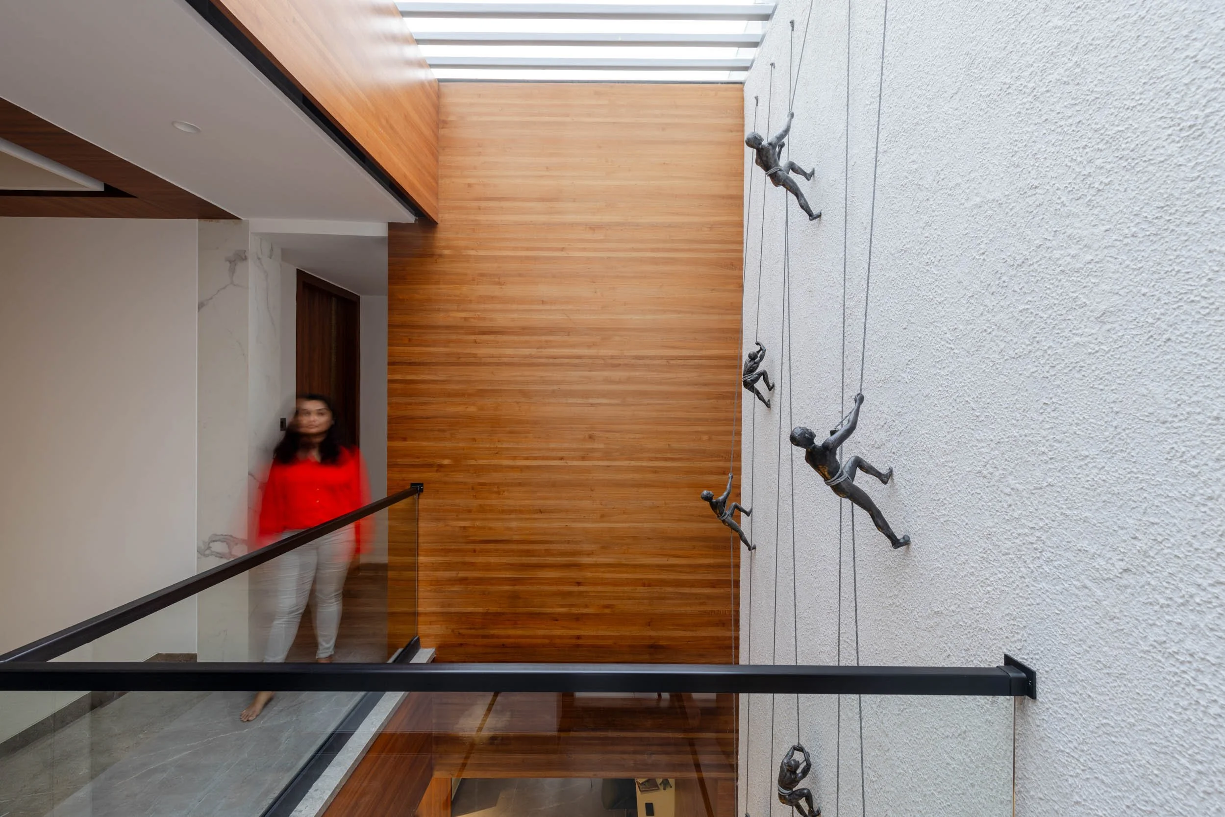 Professional interior architectural photography of a modern residential home, highlighting a bright multi-level layout, sleek glass railings, and abundant natural light.