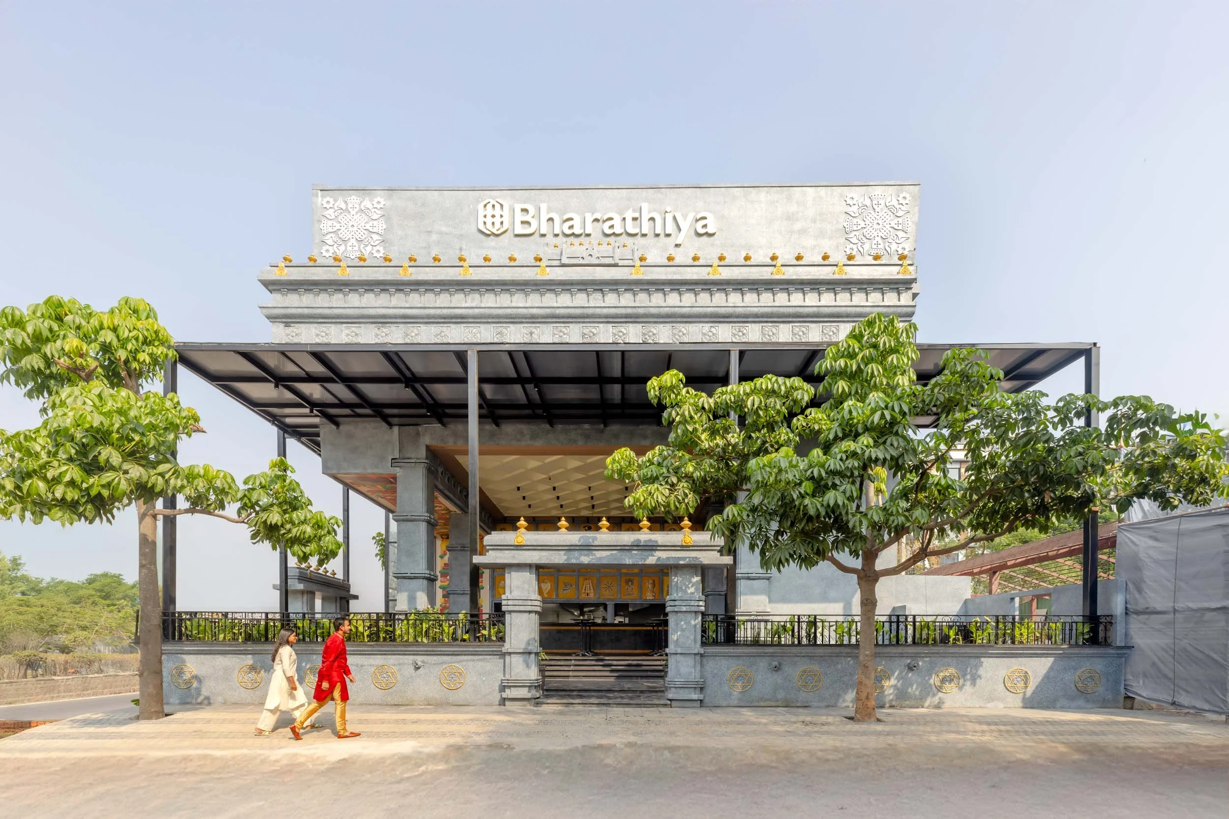 Commercial exterior architectural photography showcasing a modern hospitality venue, highlighting entrance canopy design, landscape integration, and daytime restaurant architecture