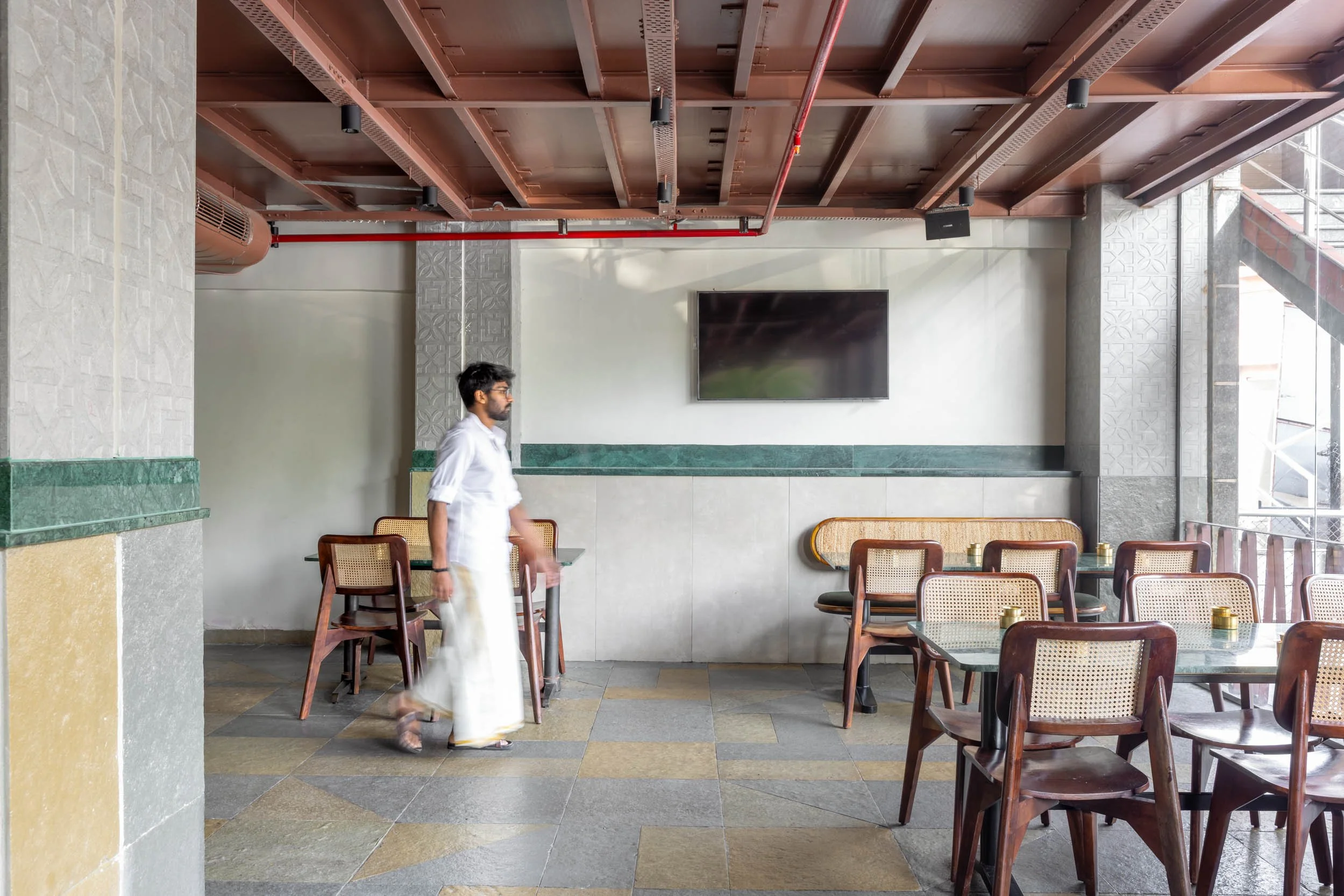 Commercial interior photography showcasing a modern restaurant dining room, highlighting custom wooden ceiling architecture, natural daylighting, and inviting hospitality interior design.