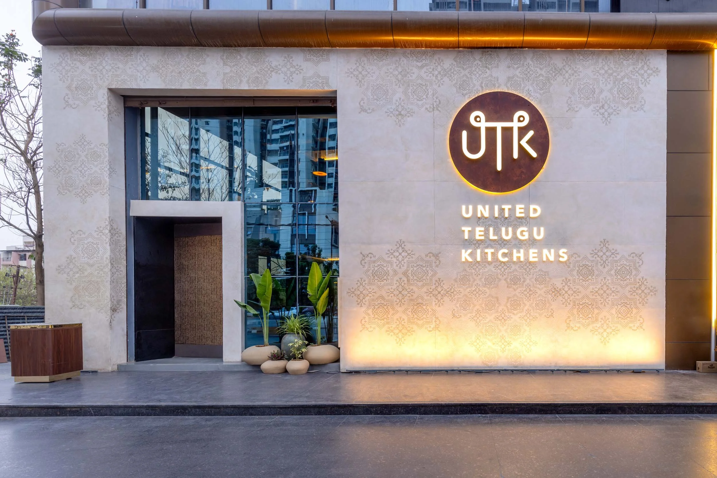 Commercial architectural photography showcasing a modern restaurant exterior at dusk, highlighting custom facade textures, storefront design, and inviting hospitality lighting