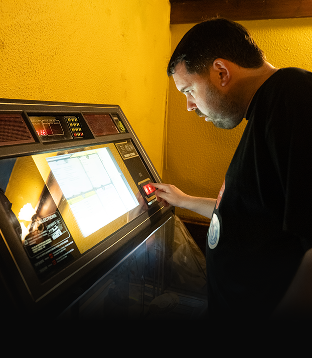A man using a touchscreen voting machine in a polling station.