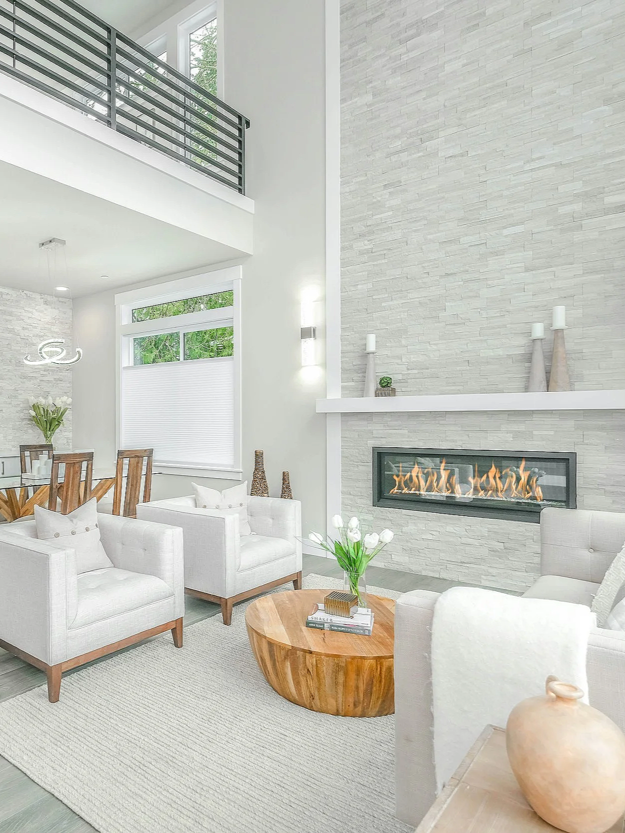 Finished living room renovation with custom interior finishes, modern fireplace, large windows, and natural light