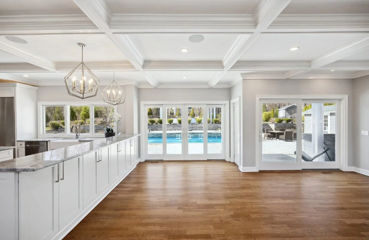 Custom kitchen renovation with custom cabinetry, Taj Mahal quartzite countertops, island seating, designer lighting, and premium finishes