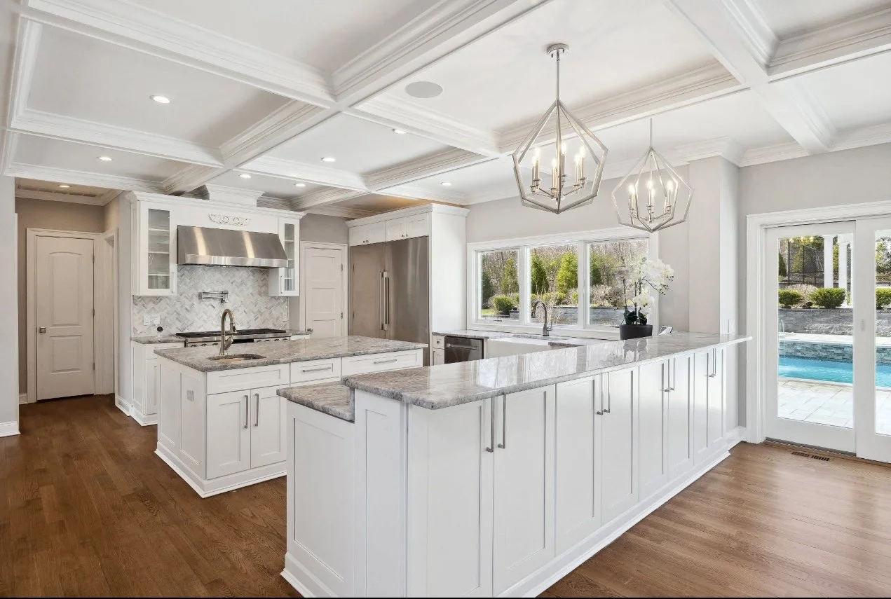 Custom kitchen renovation with custom cabinetry, Taj Mahal quartzite countertops, island seating, designer lighting, and premium finishes