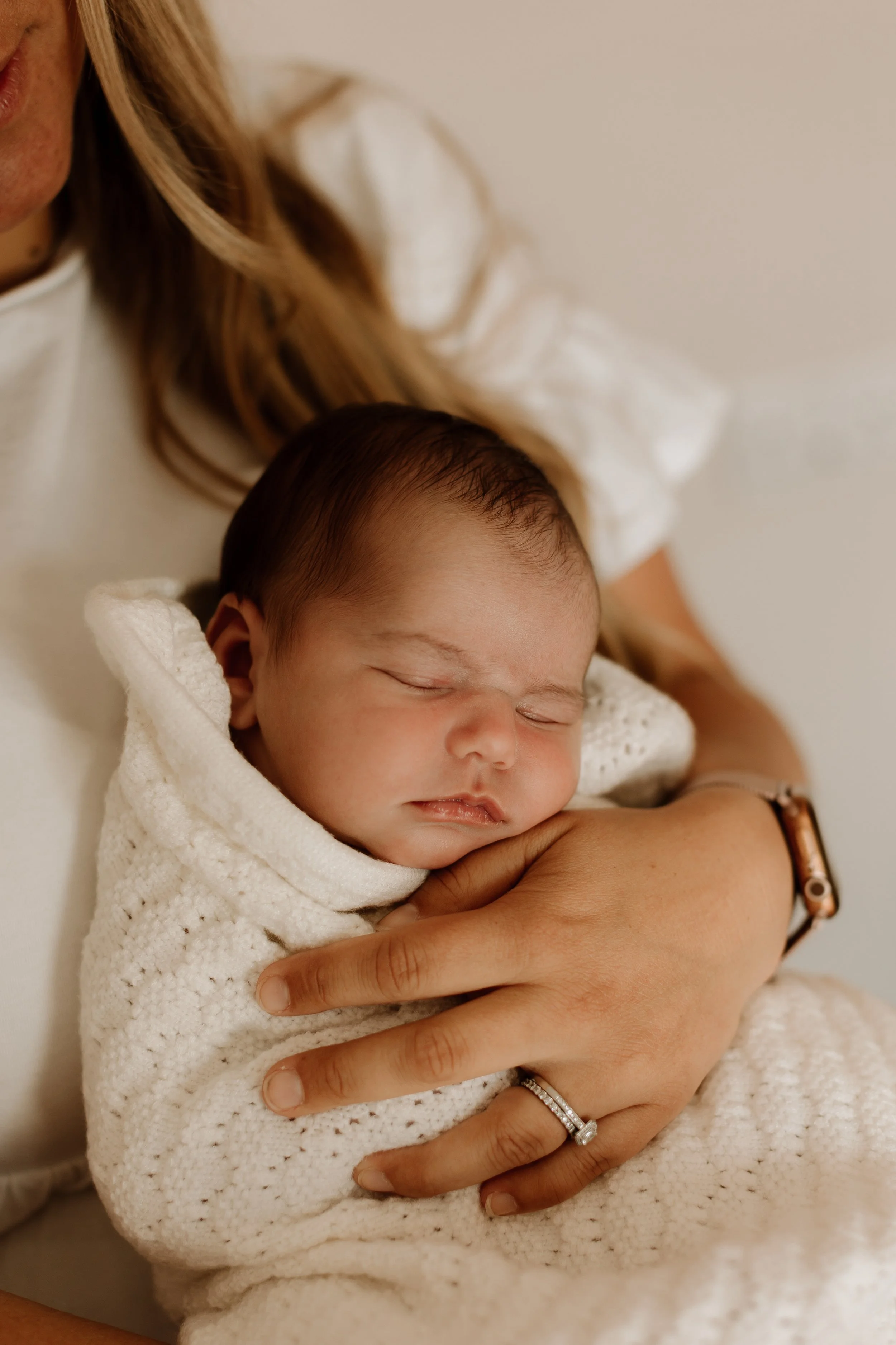 Baby cuddled during a natural home newborn session in Oakville