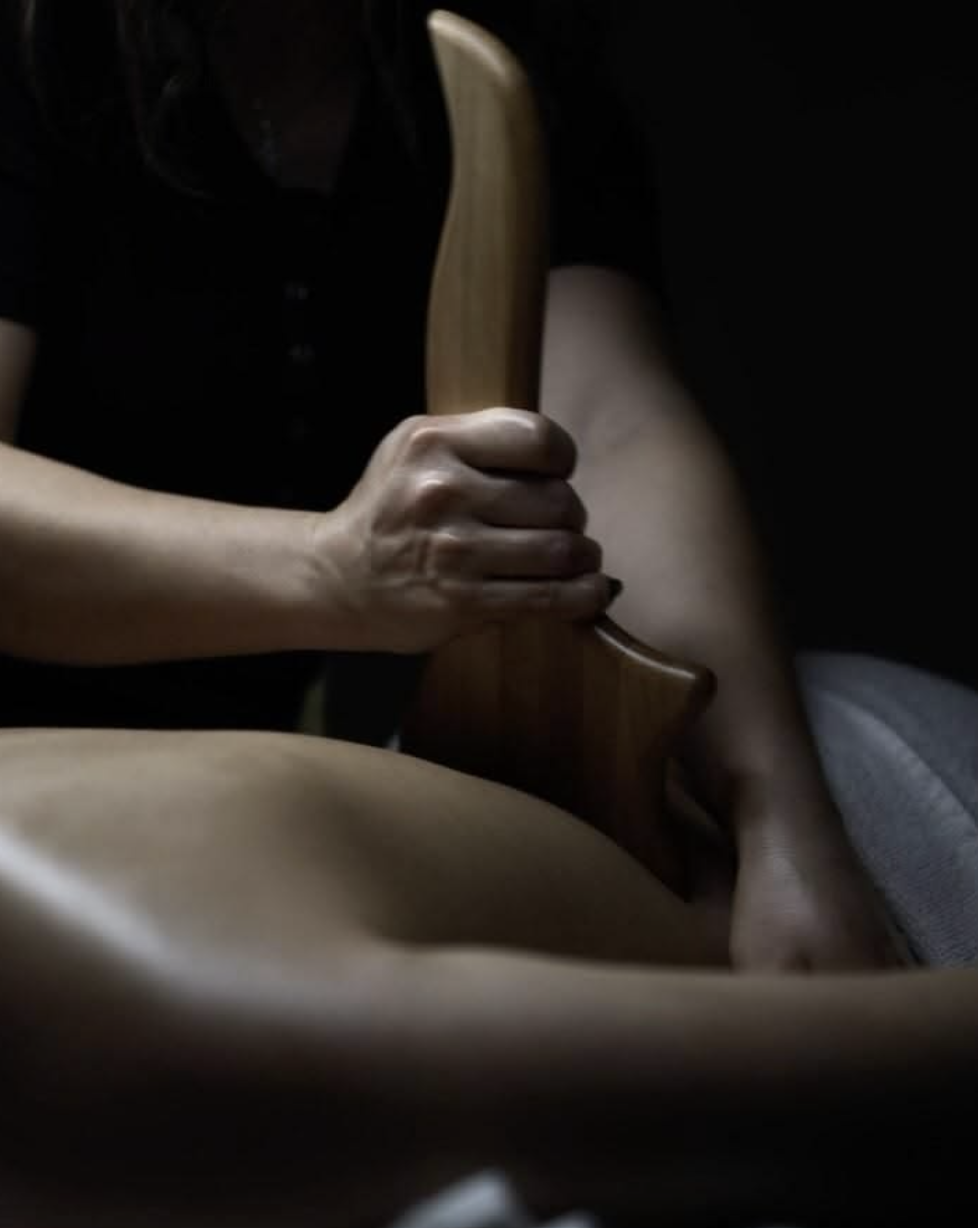 Colombian Wood Therapy maderoterapia treatment using a wooden sculpting tool on the abdomen for body contouring in Marylebone, London.