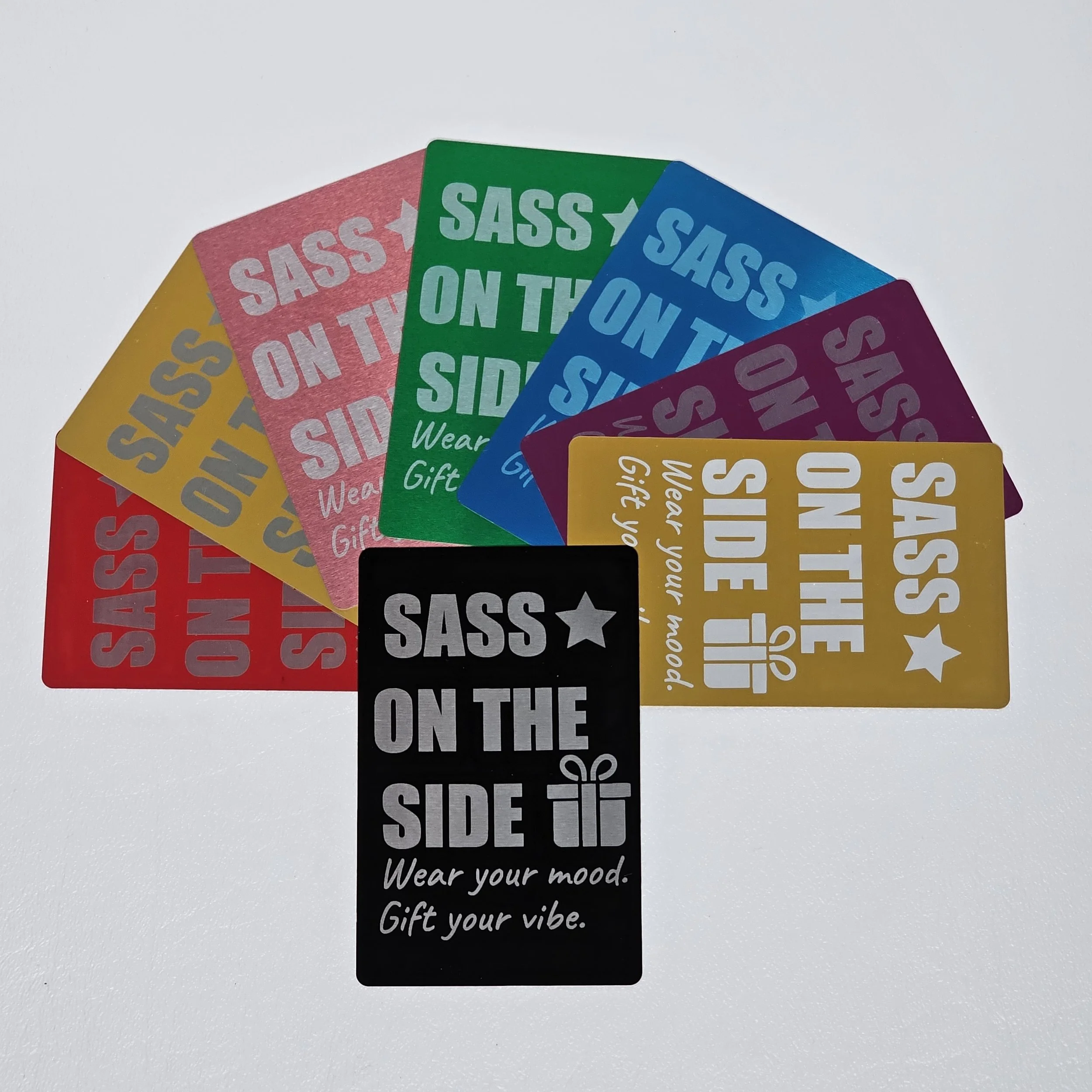 Colorful gift tags with the phrase "SASS ON THE SIDE." Each tag has a different background color and includes the phrase, a star or gift icon, and the words "Wear your mood. Gift your vibe."