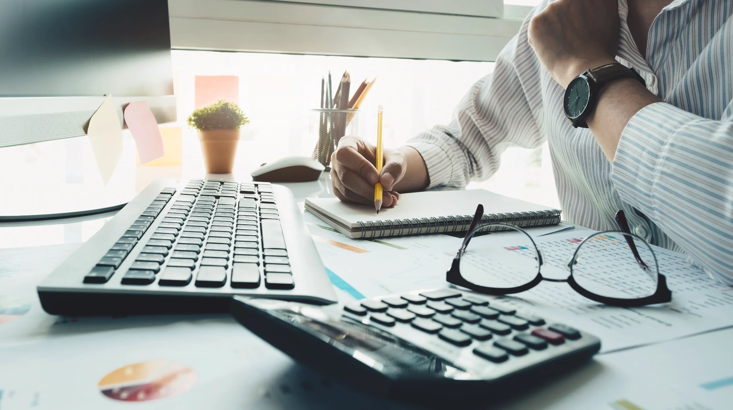 Detailaufnahme von administrativen Arbeiten an einem Schreibtisch mit Dokumenten, was symbolisch für Transparenz und die offiziellen Kontaktdaten unserer Einkaufsberatung steht.