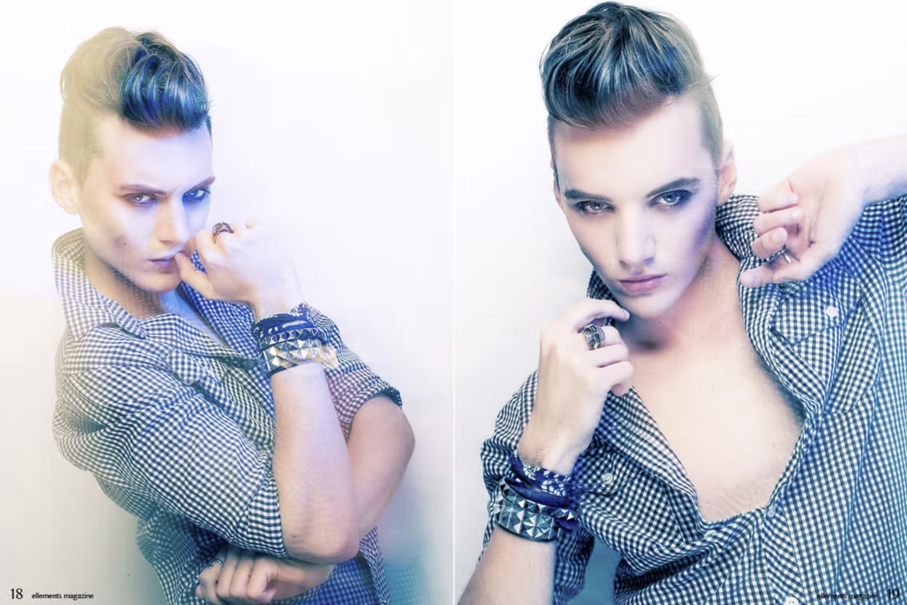 A woman with short, two-toned hair in blue and pulled back on one side, wearing a checkered shirt, rings, and bracelets, looking directly at the camera with a hand near her face.