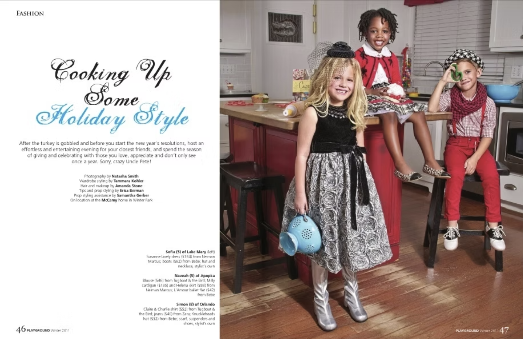 Three young girls dressed in holiday-themed outfits in a kitchen, with one sitting on a counter and two standing nearby, smiling and posing for the camera.