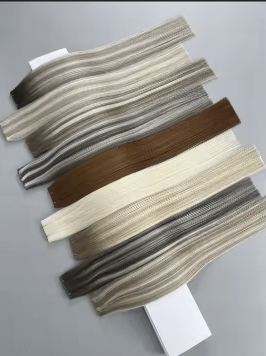 Group of fabric swatches in various shades of beige, brown, gray, and cream, arranged on a gray surface.