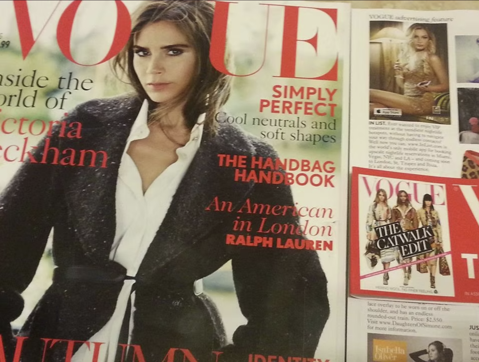 A magazine spread featuring Victoria Beckham on the cover of Vogue, with headlines about neutral and soft shapes, and the handbag handbook. Smaller images on the right show additional fashion features and a Vogue cover with three women.