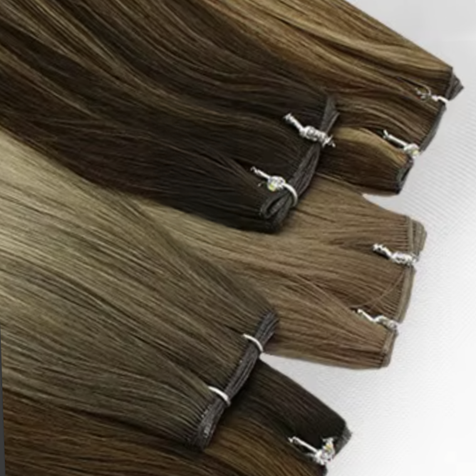 Multiple hair extensions in shades of brown, bound with small elastic bands, laid out on a flat surface.