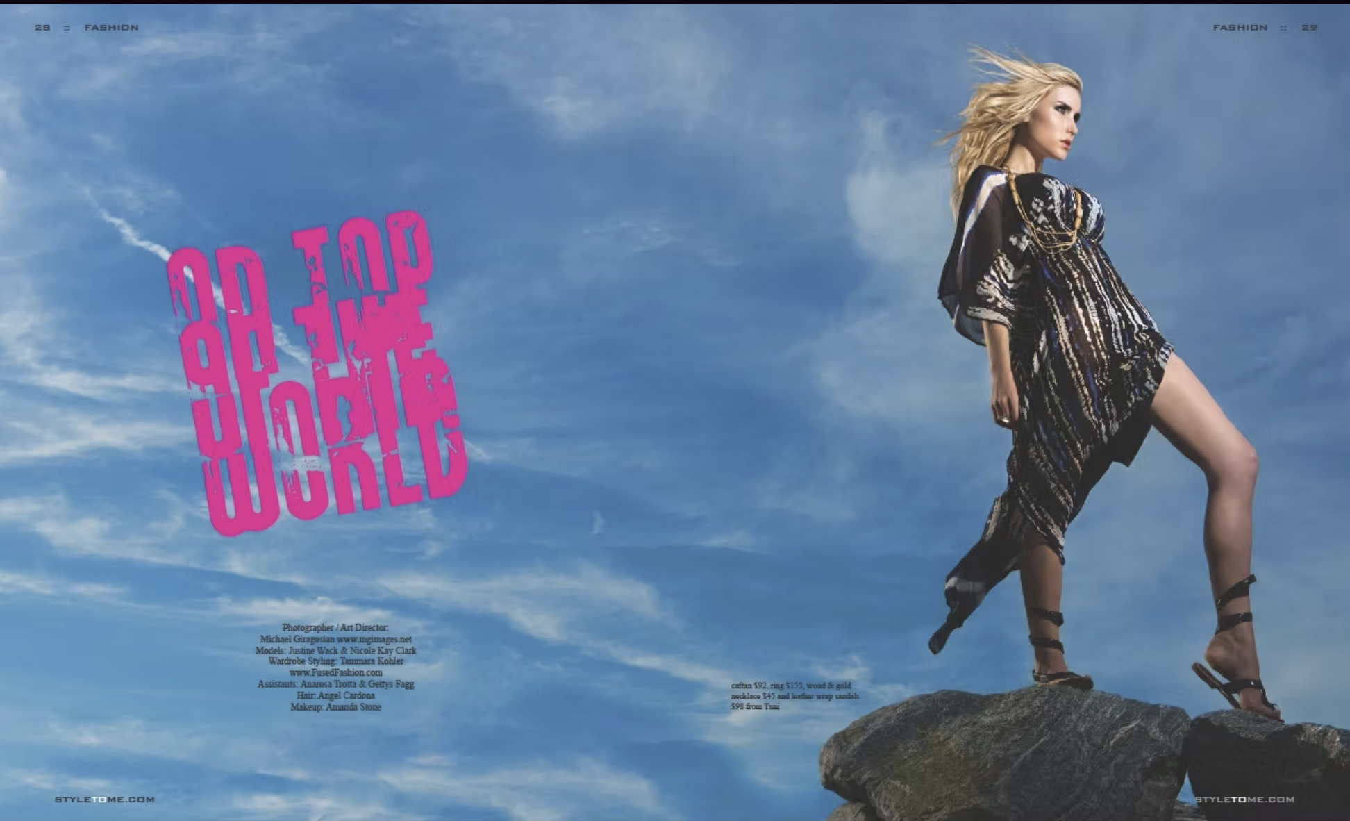 Model standing on a rock formation against a cloudy sky background, wearing a patterned outfit and high heel shoes, with wind blowing her blonde hair.