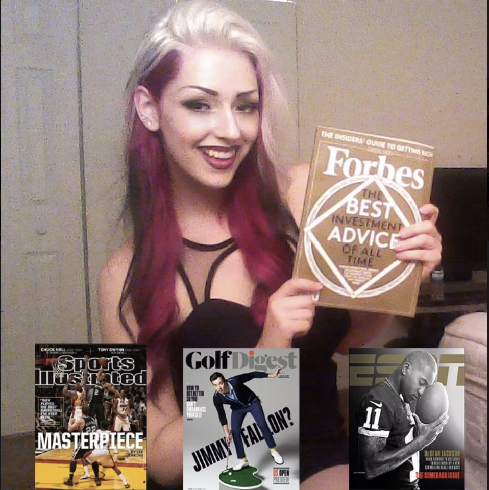 A young woman with platinum blonde and purple hair smiling and holding a Forbes magazine that has 'The Best Investment Advice of All Time' written on it. She is wearing a black strappy top and earrings, standing against a beige wall.